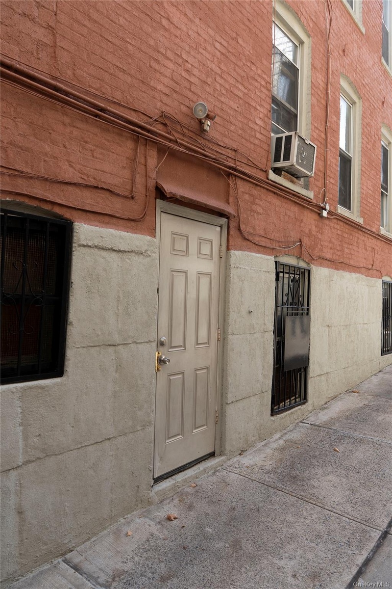 Brick exterior with a paneled door leading to basement
