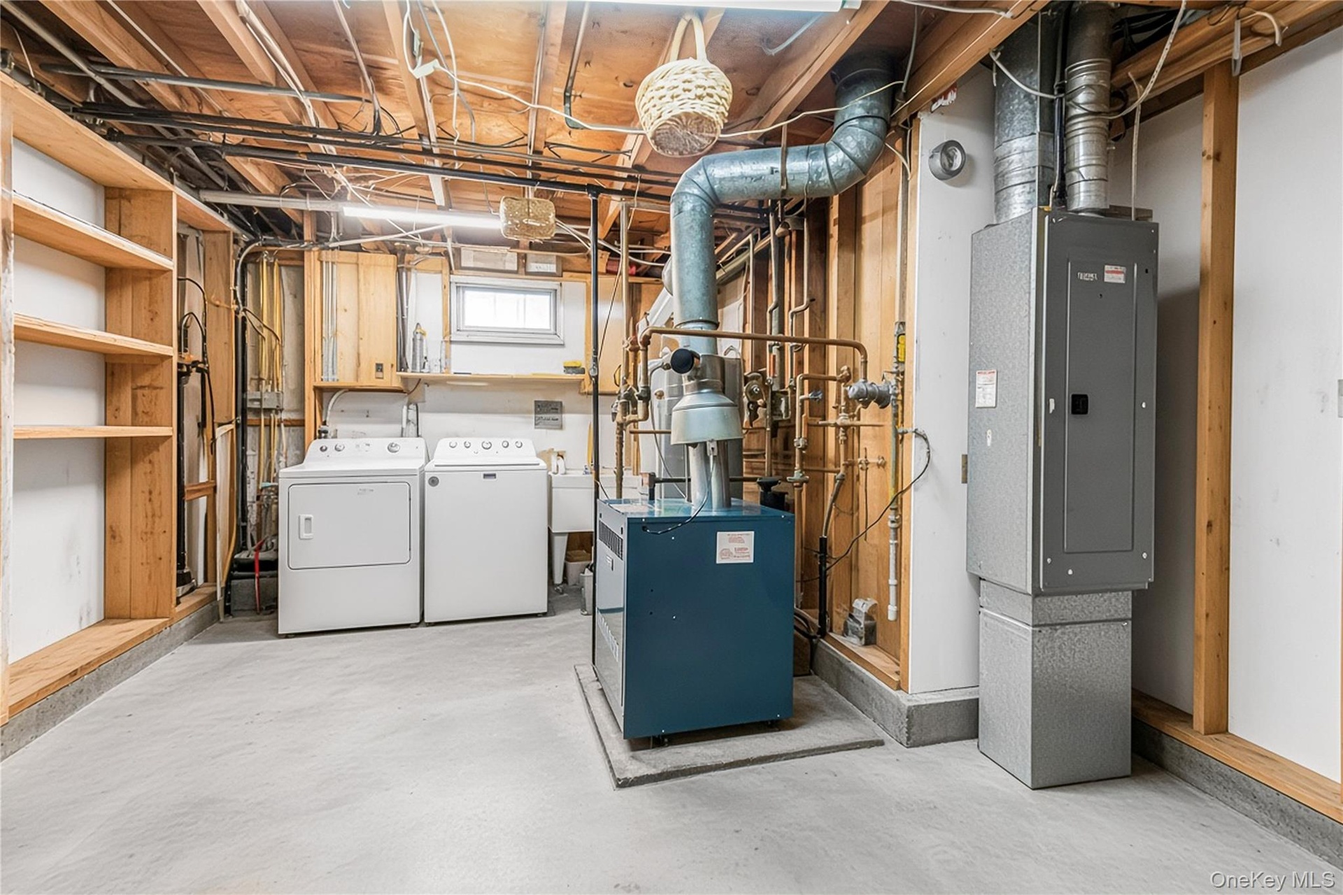 Laundry area with concrete flooring, exposed ceiling joists, and a utility sink