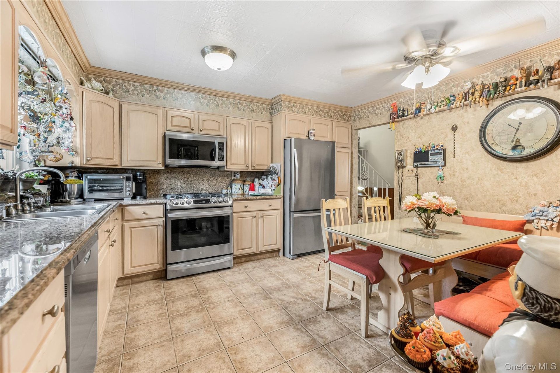 Kitchen featuring light-toned cabinetry, tile flooring, and stainless steel appliances