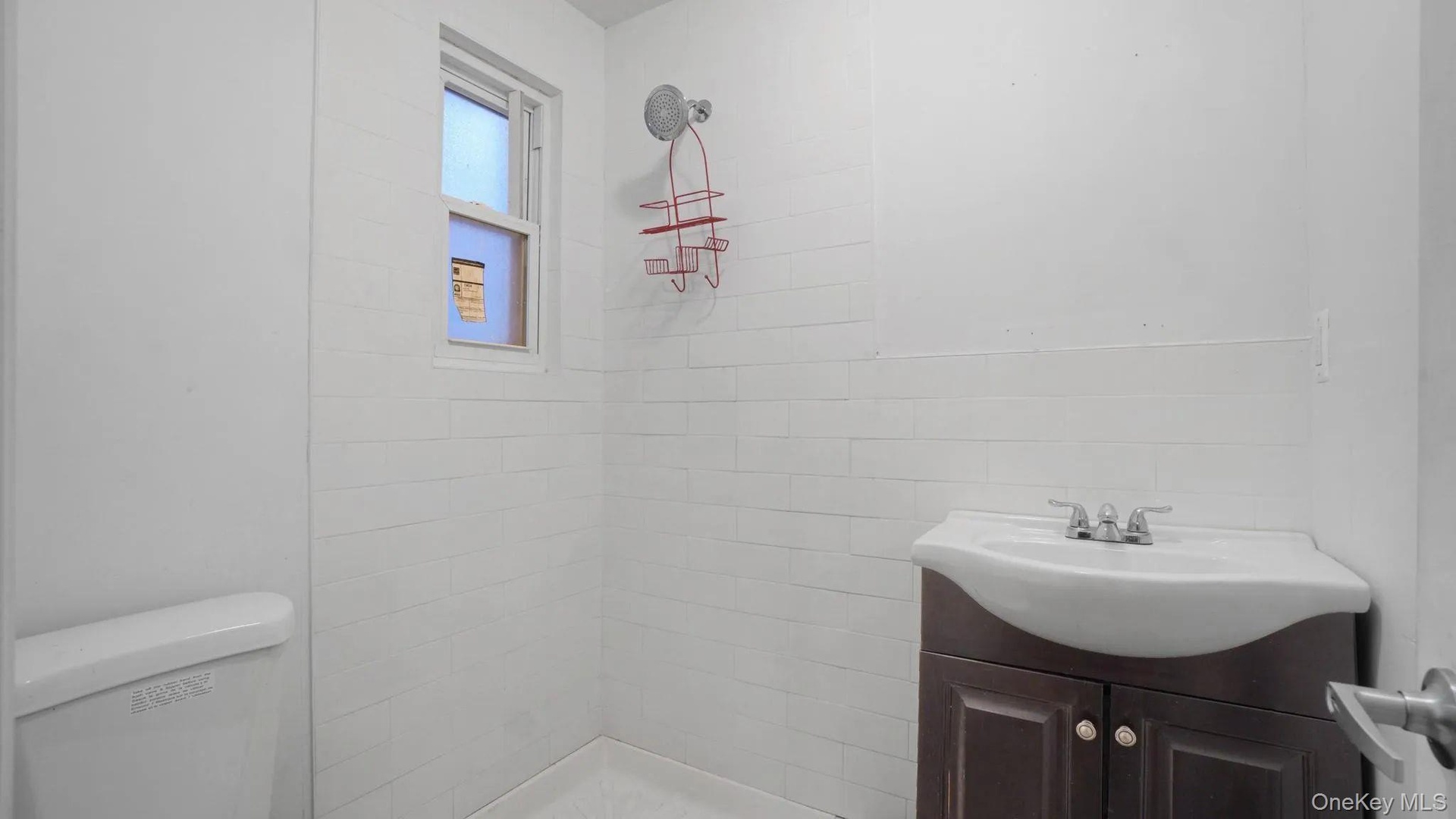 Bathroom featuring vanity, tiled shower, and toilet