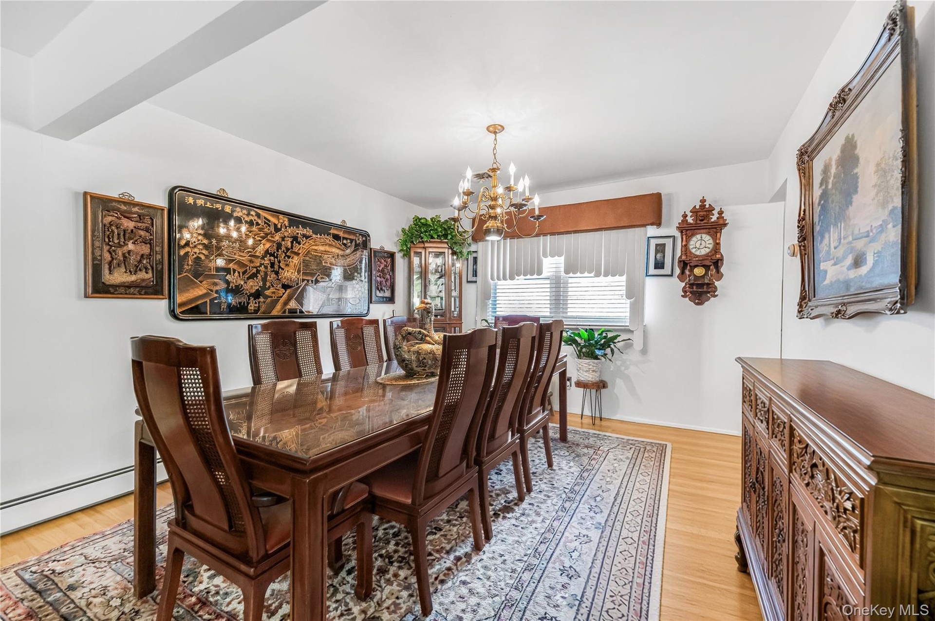 Hardwood flooring, chandelier lighting, white walls, and a built-in display cabinet
