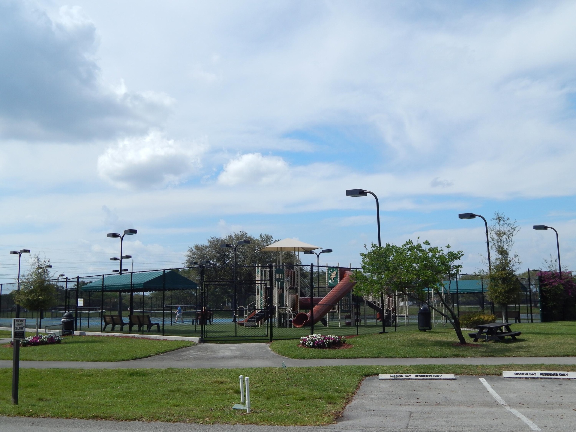 Community amenities featuring a playground, tennis courts, covered seating area, and picnic table