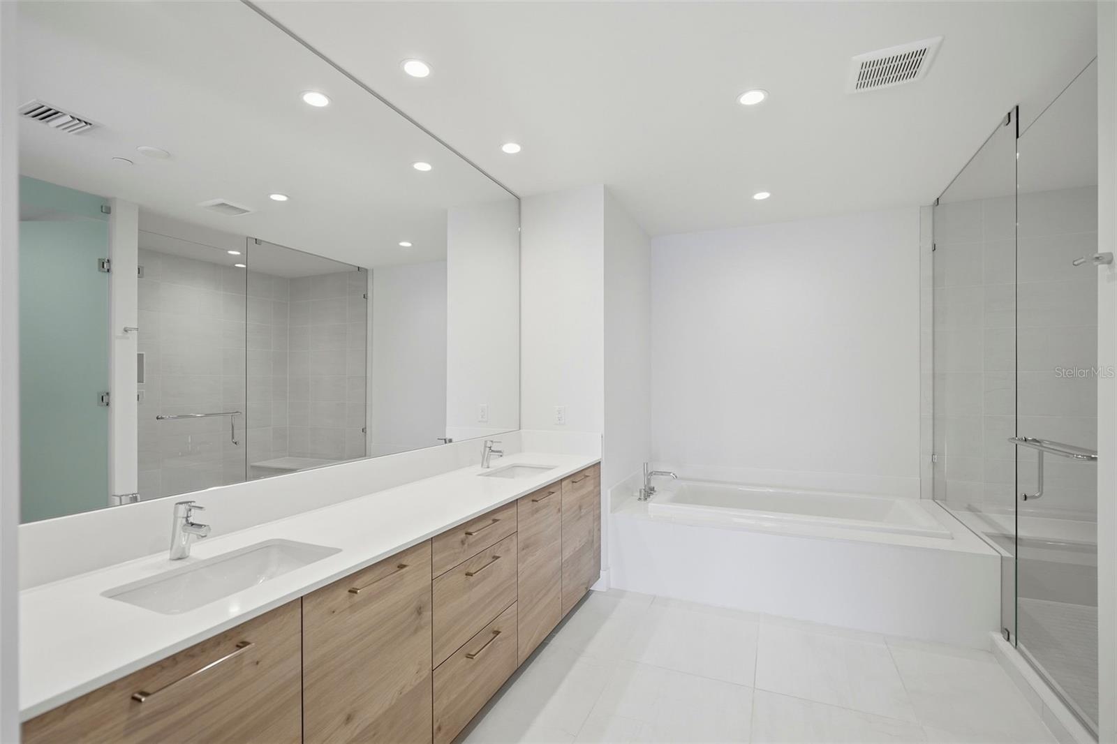 Primary Bathroom with dual sinks, oversized tub and walk-in shower