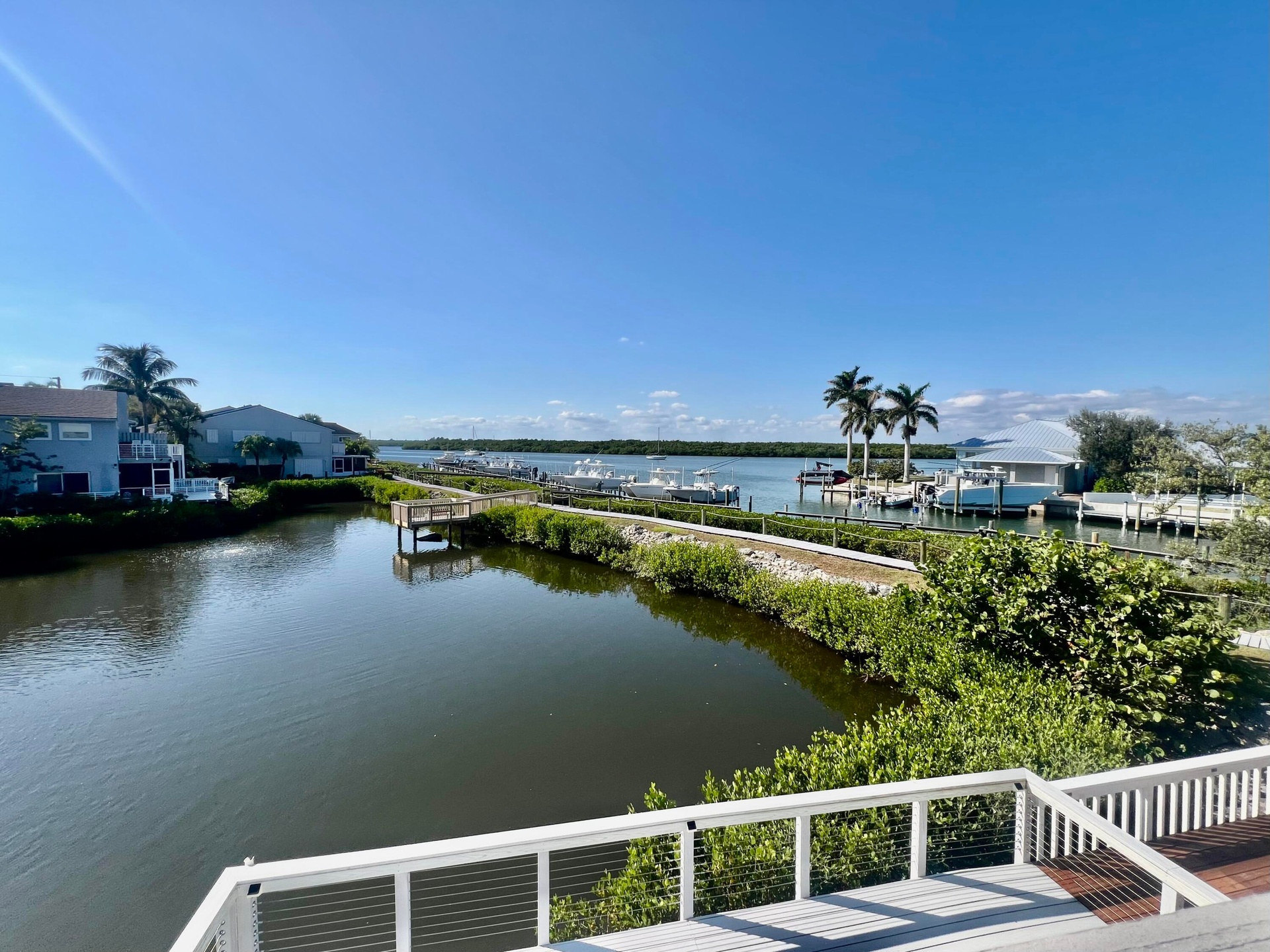Waterfront property featuring a private boat dock, marina access, and tropical landscaping