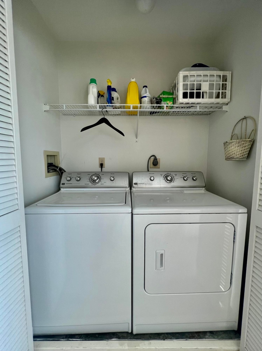 Built-in laundry closet with louvered bifold doors, wire shelving, and overhead lighting