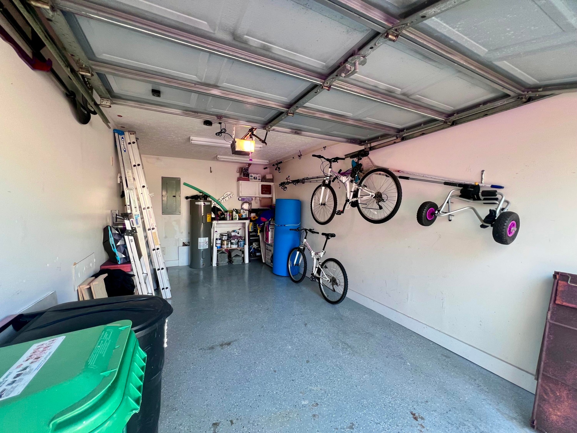 Attached garage with an overhead door, smooth interior walls, and an epoxy-coated concrete floor