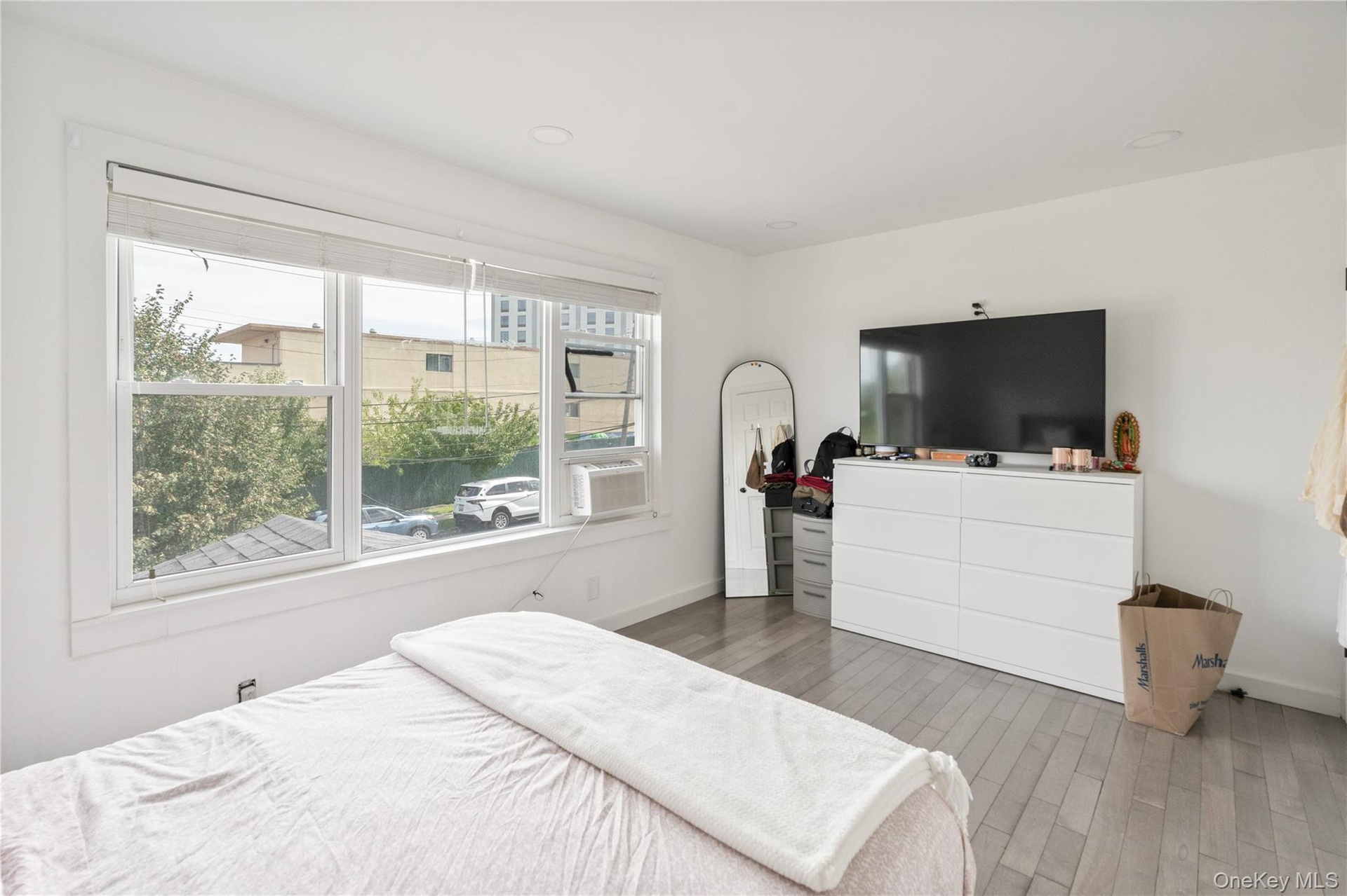 Spacious and bright bedroom featuring modern flooring, recessed lighting, and oversized windows providing abundant natural light. 2nd Floor Unit