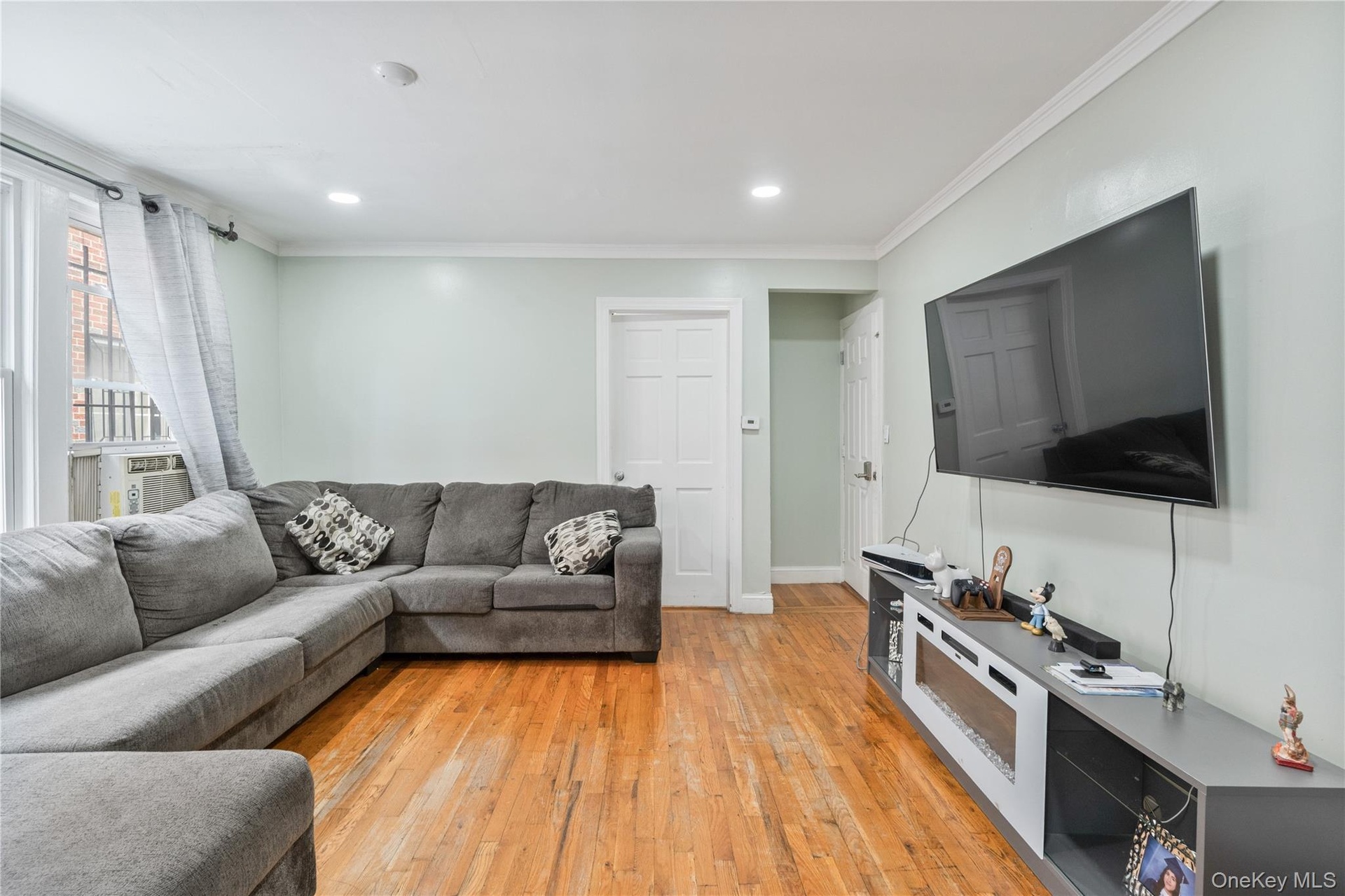 Spacious living room featuring hardwood floors, recessed lighting, and a comfortable open layout. 1st Floor.