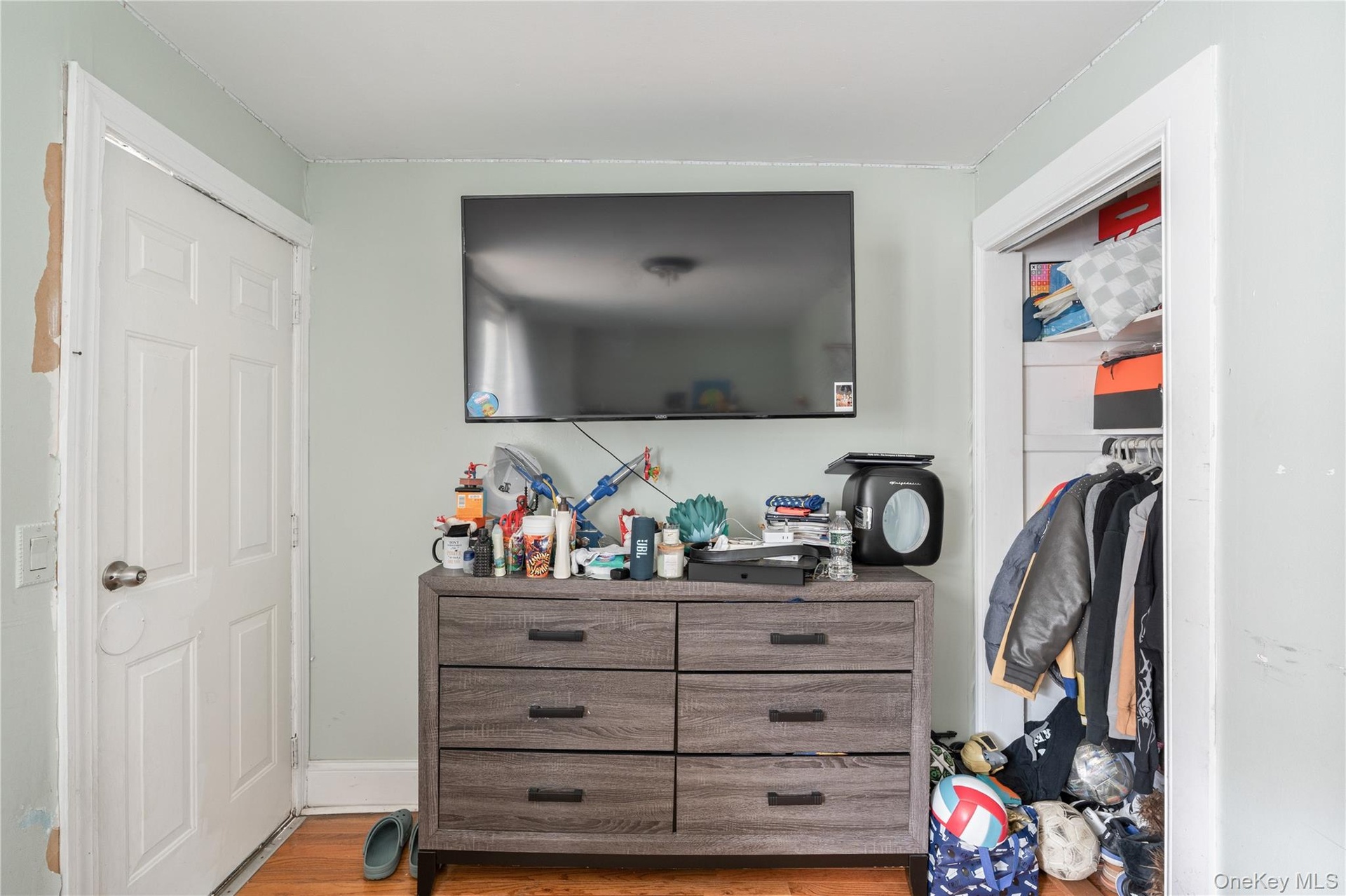 Bedroom featuring a spacious closet, hardwood floors, and ample storage space. 1st Floor.