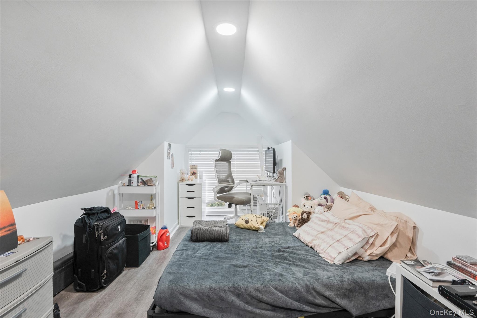 Upper-level bedroom featuring vaulted ceilings, recessed lighting, updated flooring, and a flexible layout with space for a work or study area. 2nd Fl