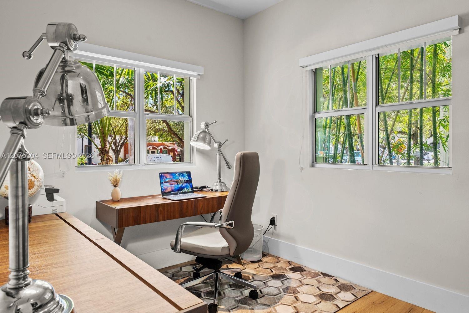Bright home office with large windows and greenery views — ideal remote-work setup in Miami Beach.
