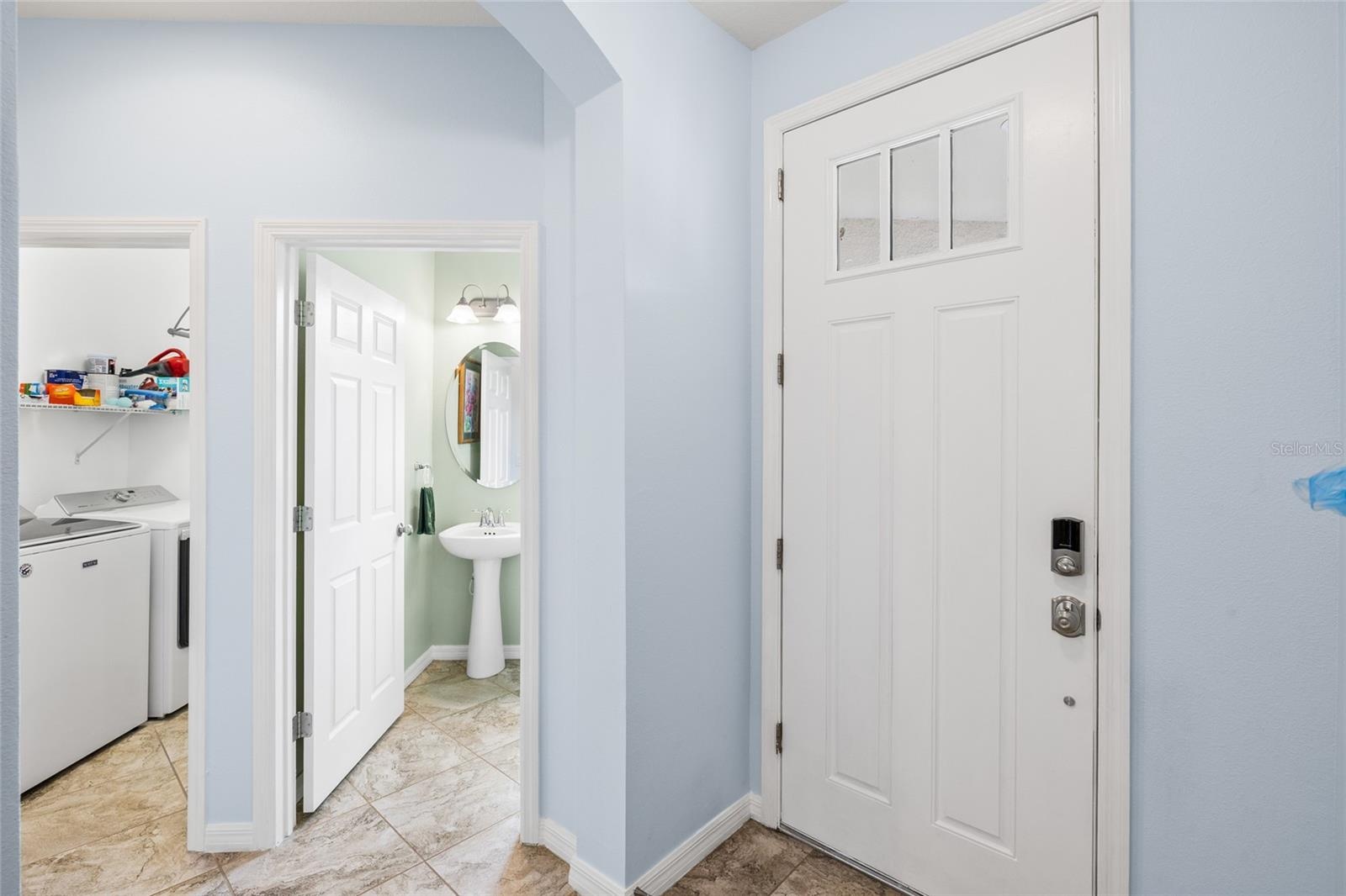 Foyer looking toward half bath and interior laundry room