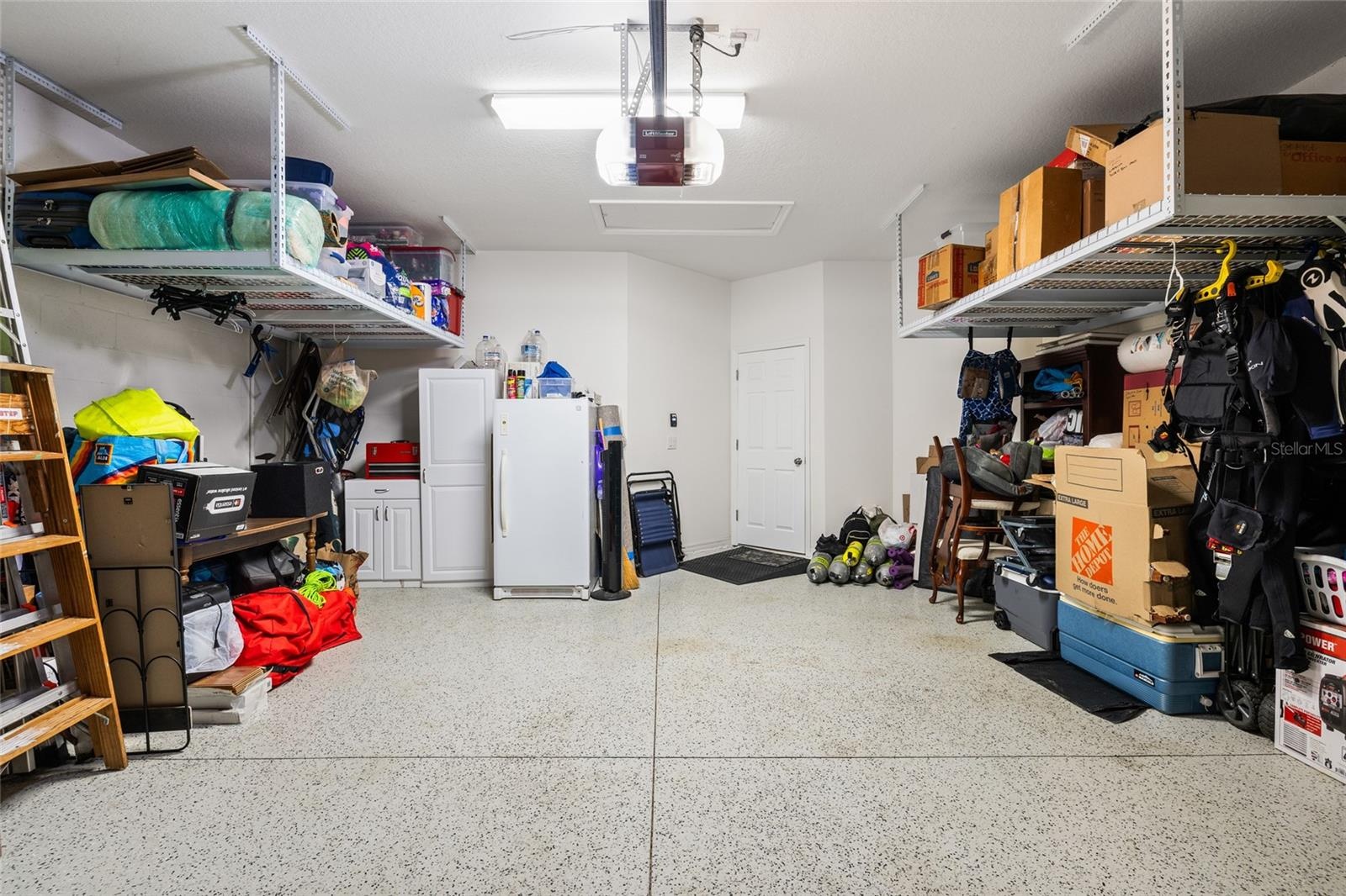 Spacious garage with finished floor and an abundance of storage.
