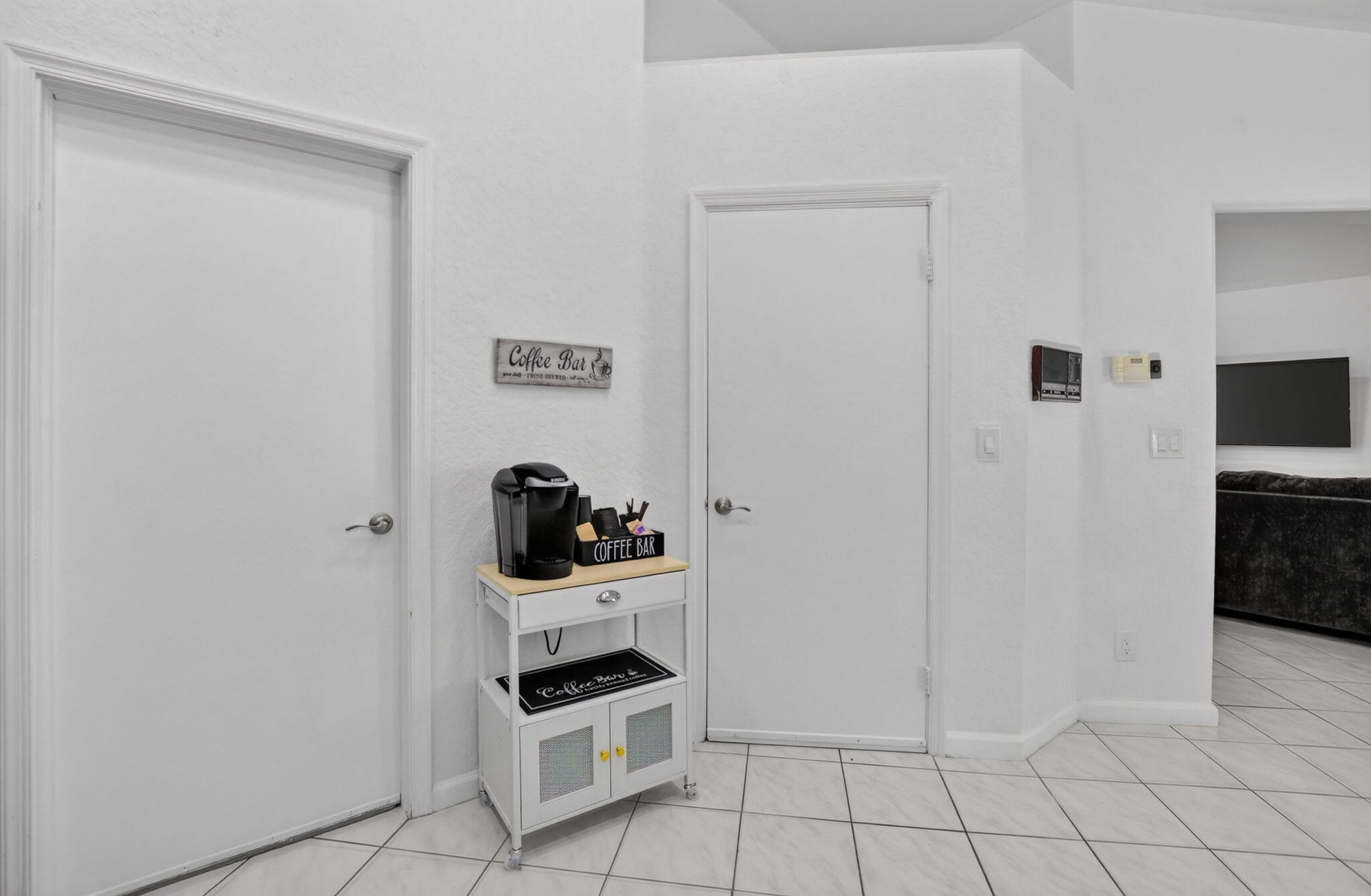 Light-toned tiled flooring, white walls, and bright white interior doors