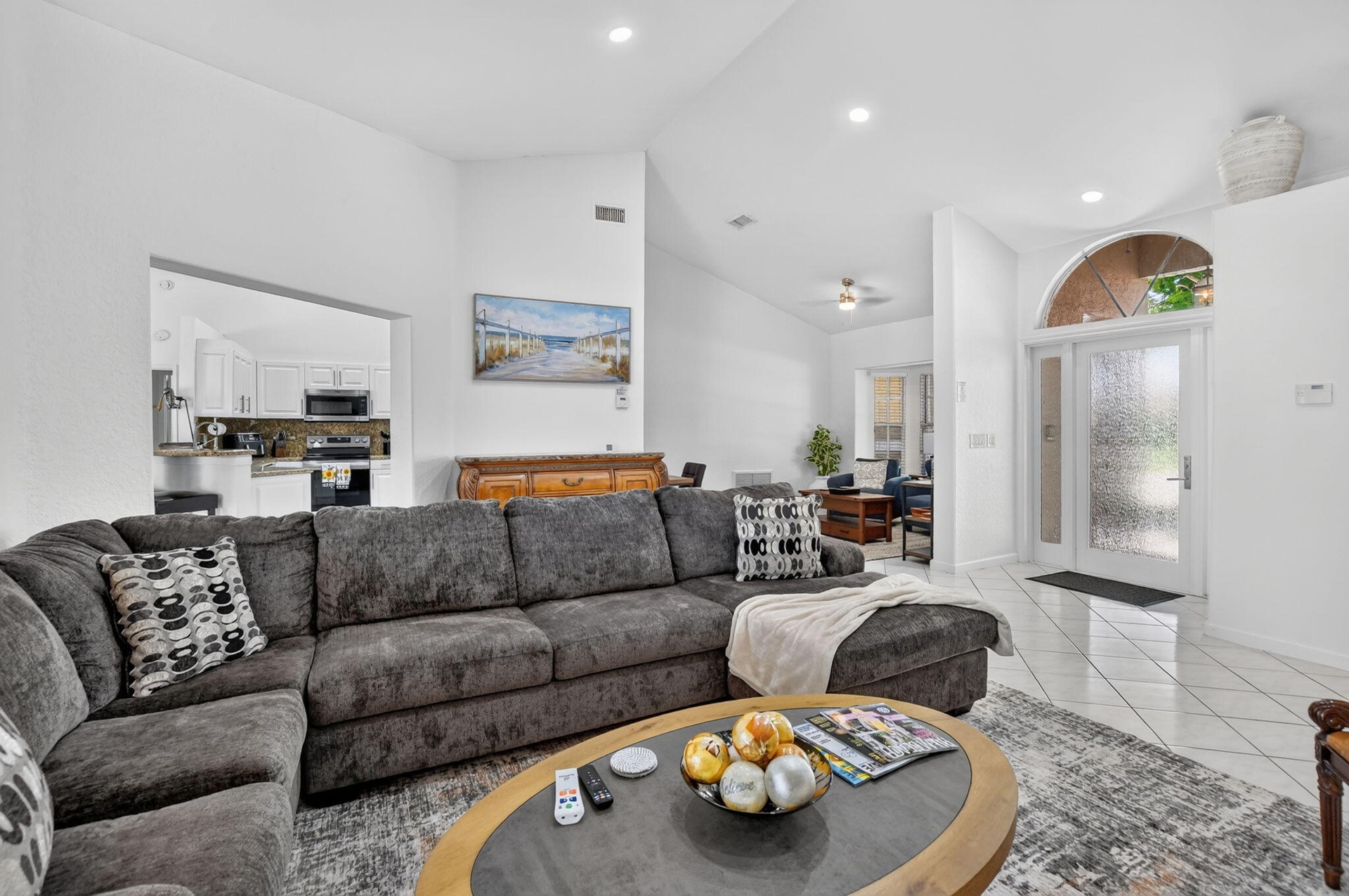 Vaulted ceilings, recessed lighting, and a kitchen pass-through
