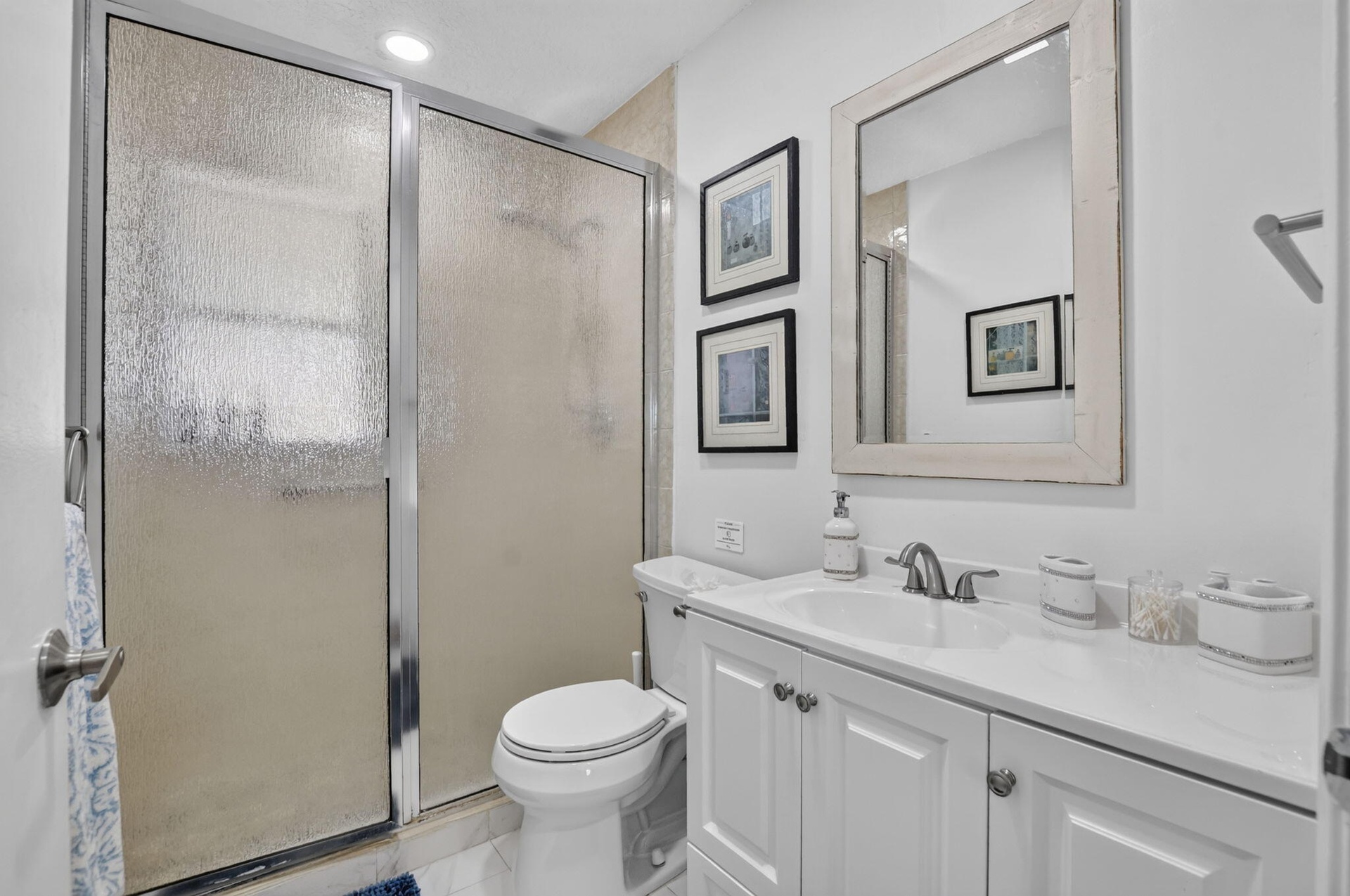 White vanity with panel cabinetry and a light-toned countertop