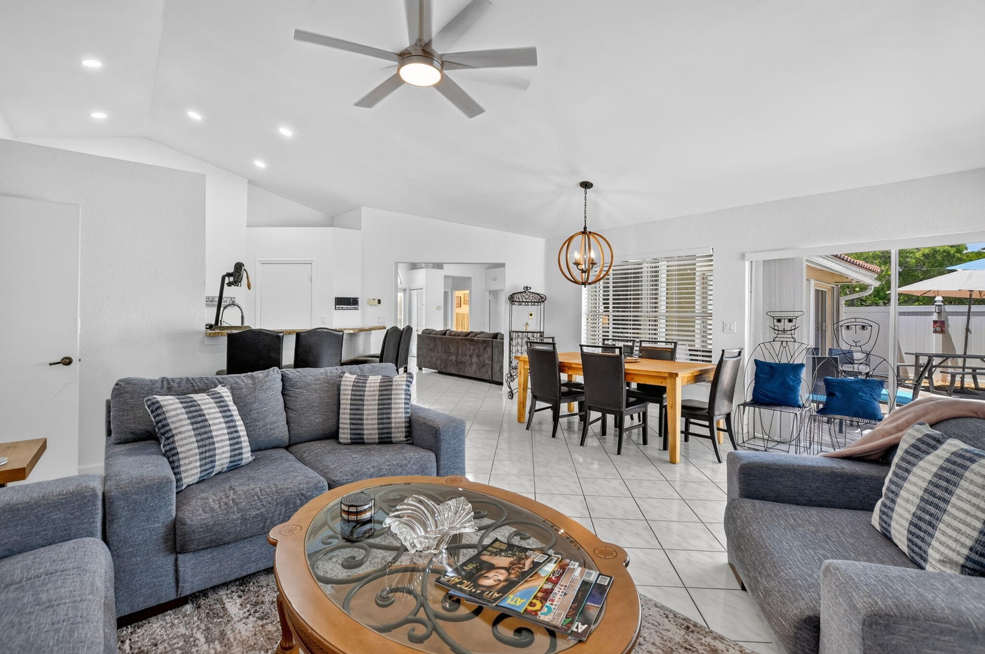 Vaulted ceiling, recessed lighting, tile flooring, contemporary ceiling fan, and sliding glass door