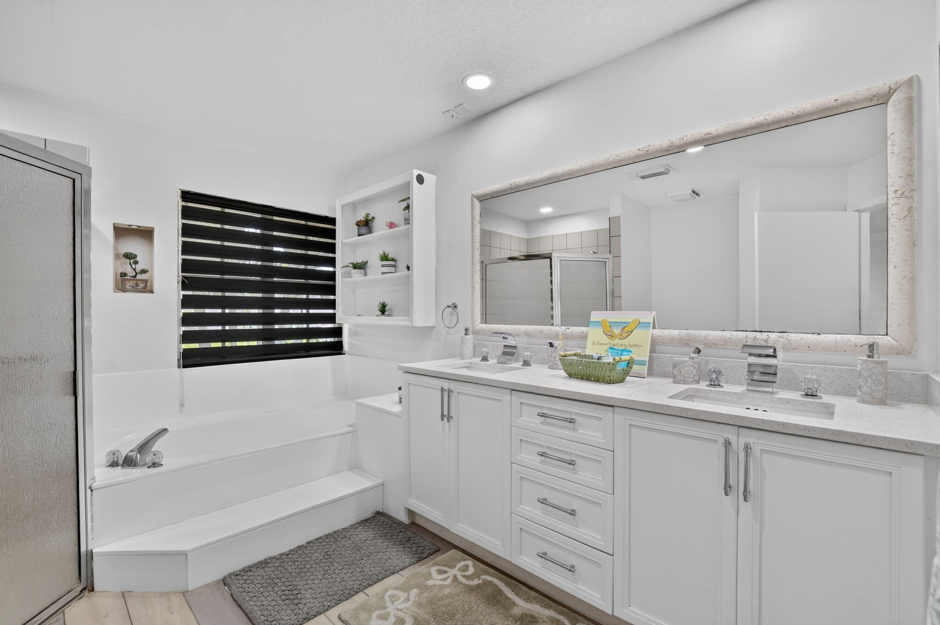 White double vanity with integrated sinks, light-toned countertop, and silver-tone fixtures