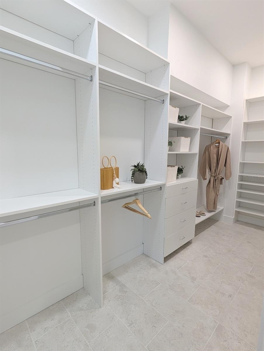 Two spacious walk in closets with custom shelving