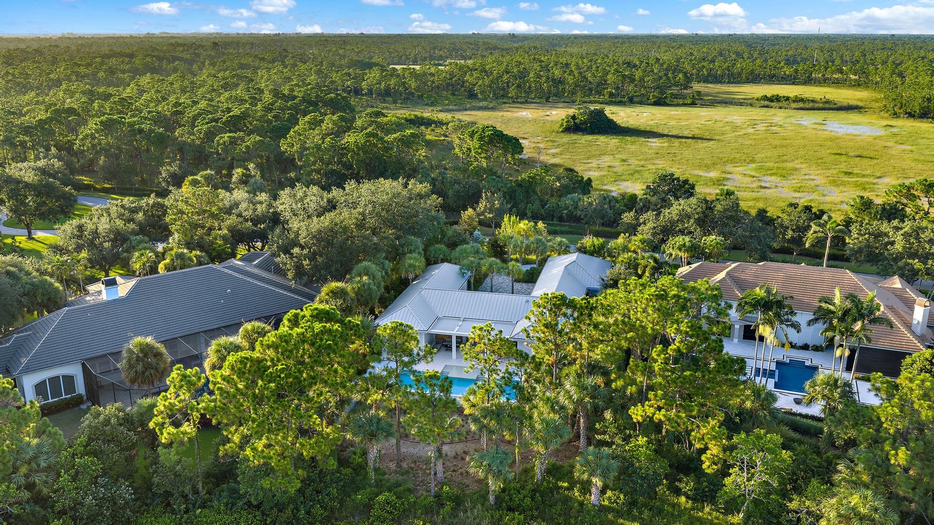Multiple residences featuring private swimming pools and surrounding lush landscaping