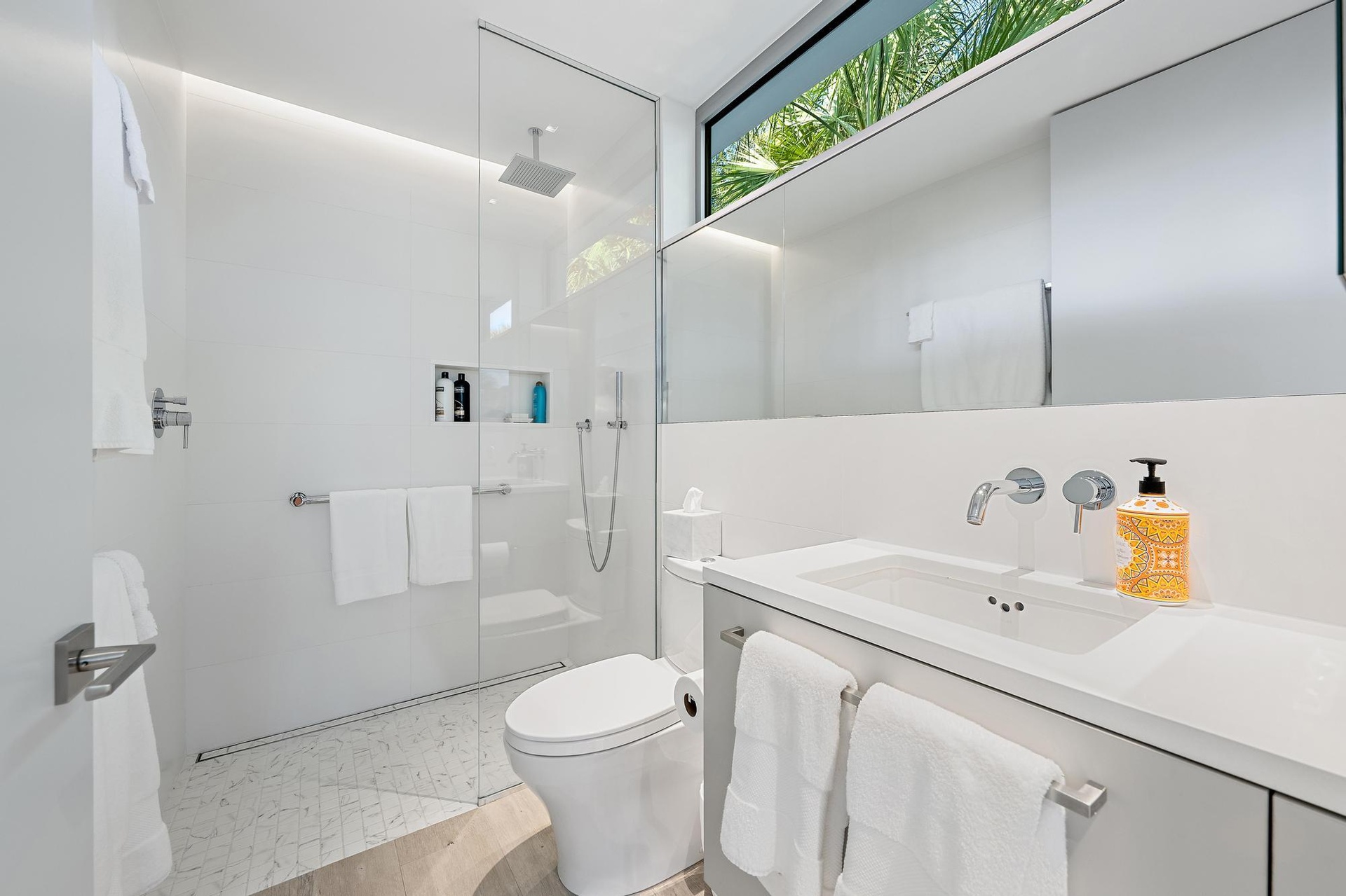 Floating vanity with an integrated rectangular sink, wall-mounted faucet, and a large mirror