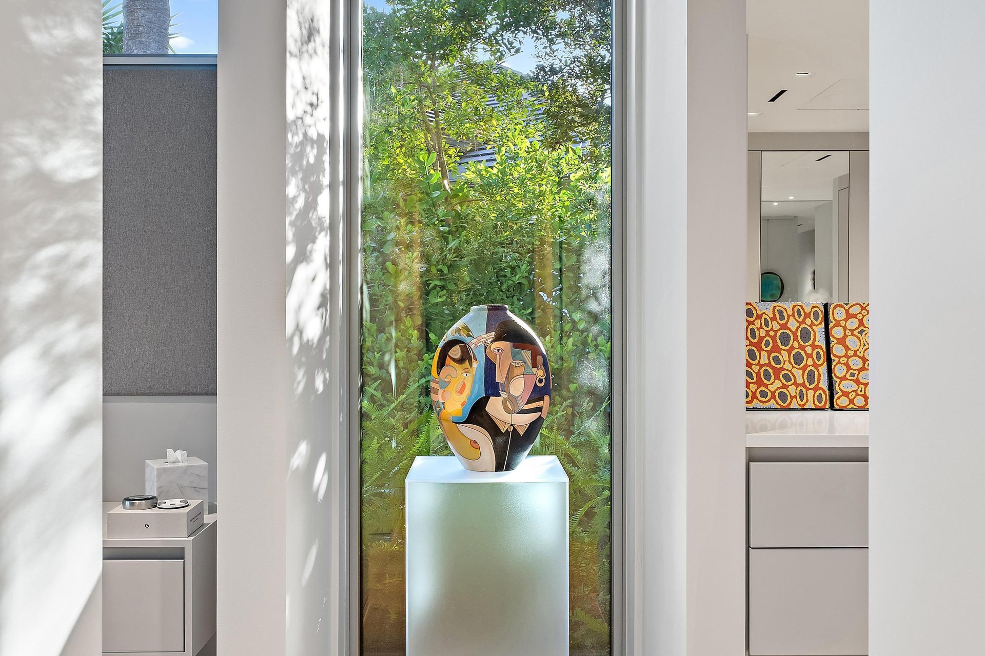 Floor-to-ceiling window with abundant natural light, showcasing built-in cabinetry, an integrated mirror, and recessed lighting