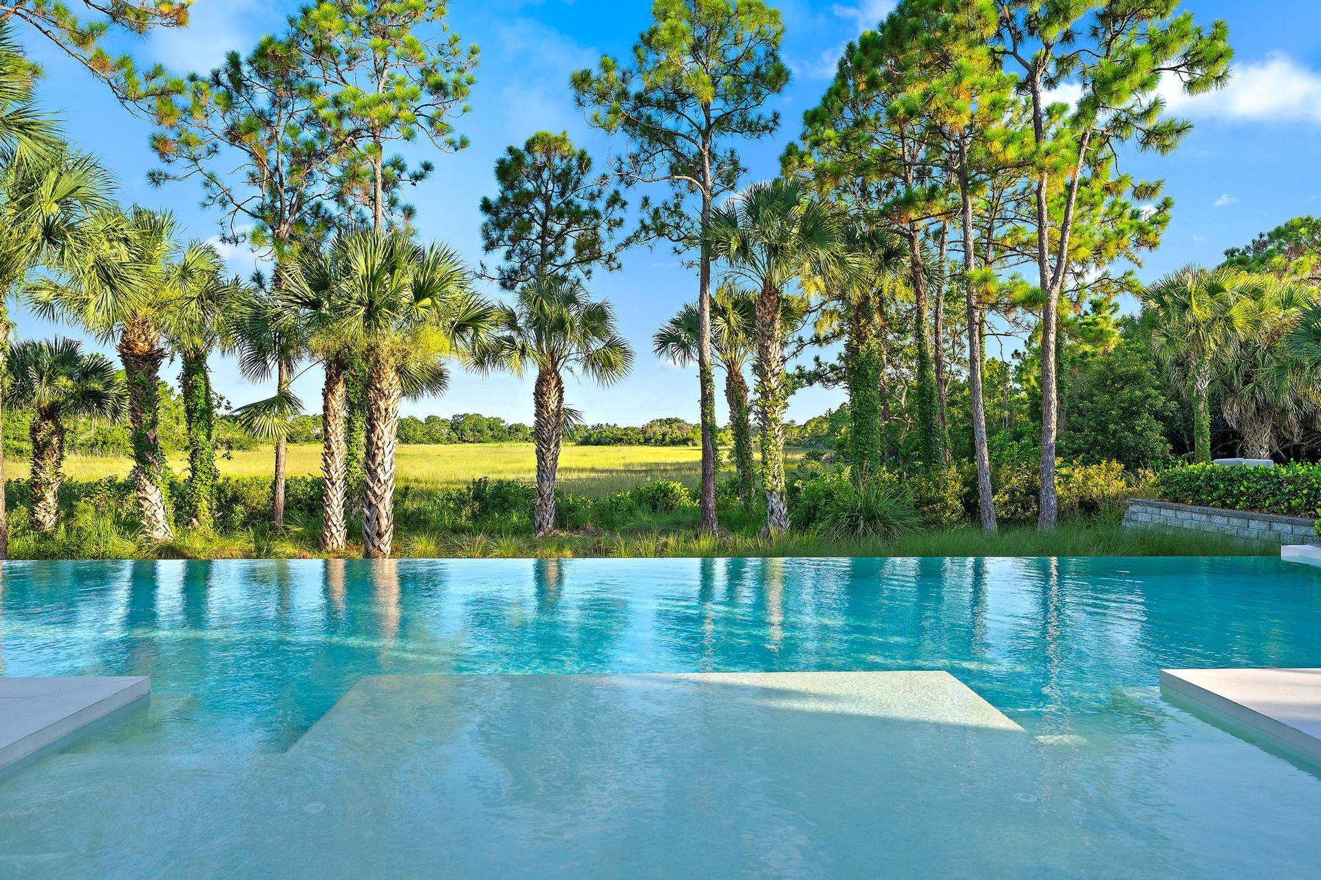 Infinity-edge pool with light-colored steps and integrated seating