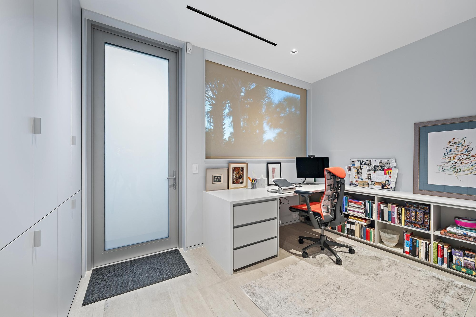 Built-in desk with three drawers, integrated shelving, and wood-finish flooring
