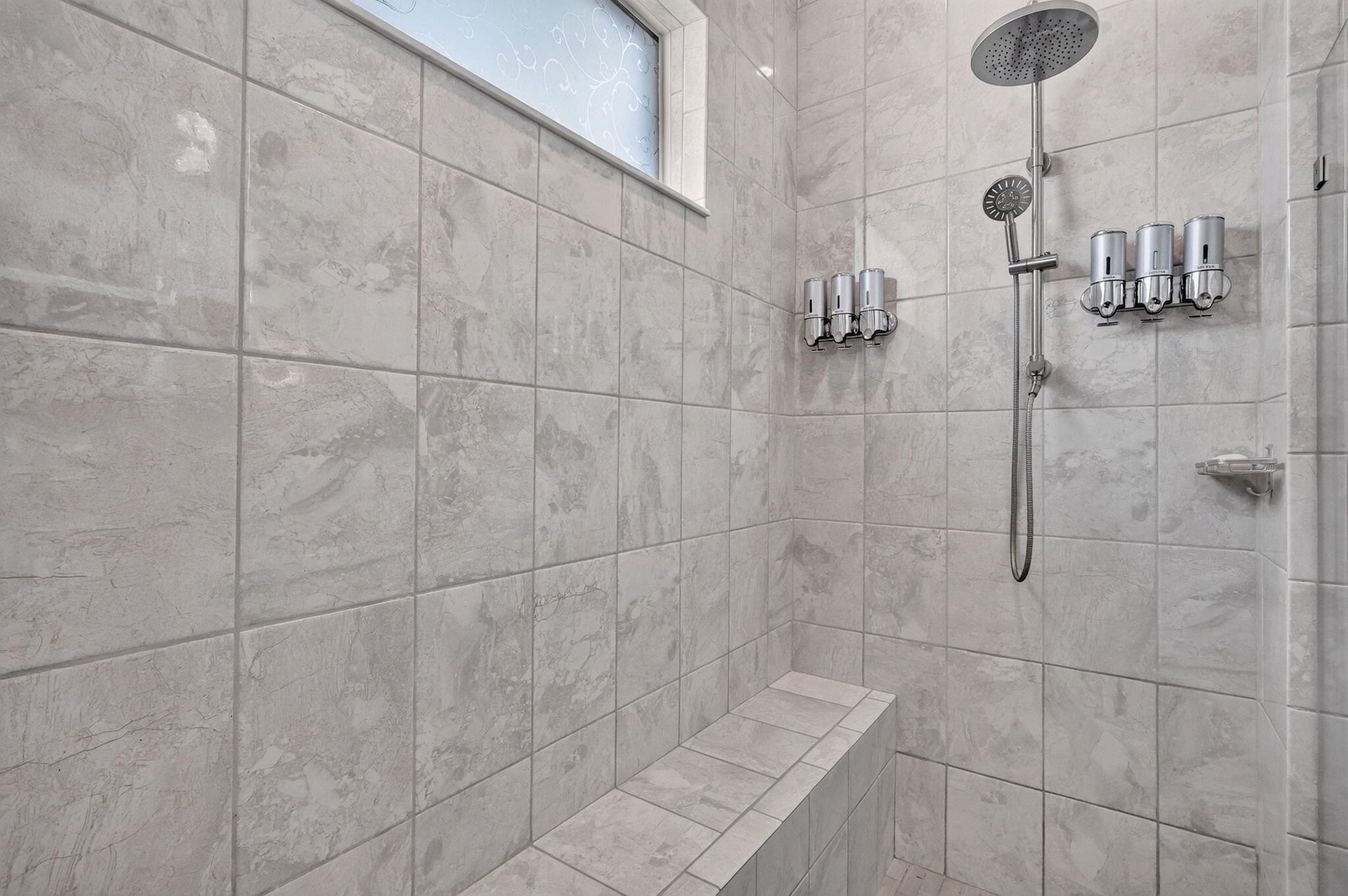 Large walk in shower with rain shower head and handle held.