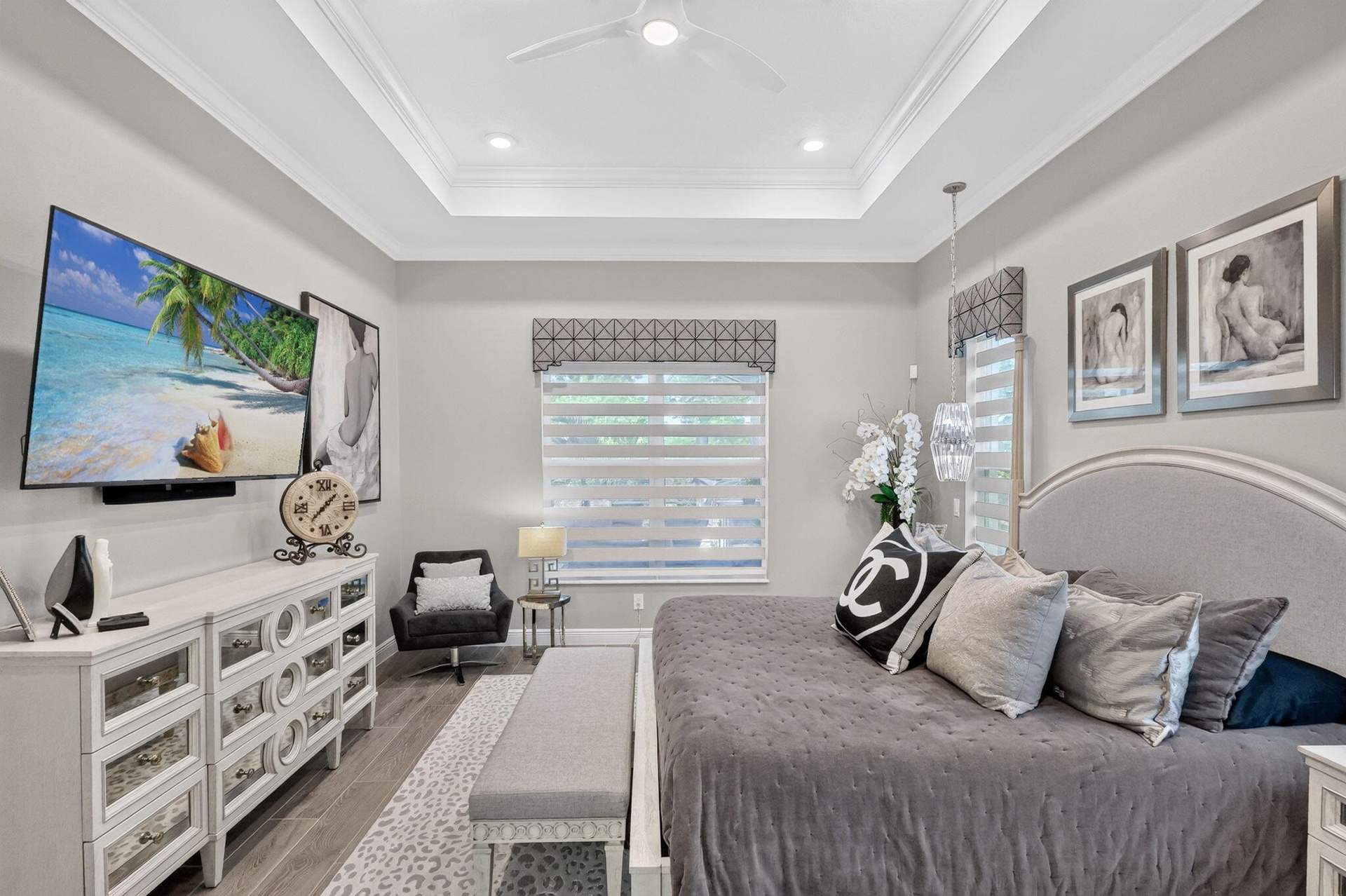 Lovely primary bedroom with custom window treatments and wood like tile flooring throughout.