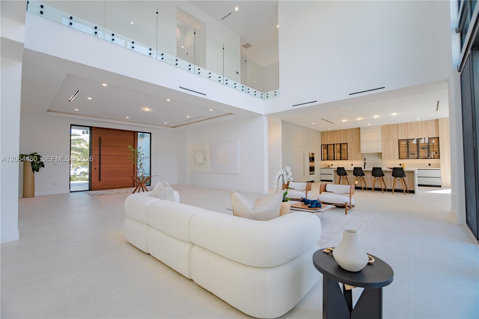 Double height great room with floor to ceiling glass overlooking the pool