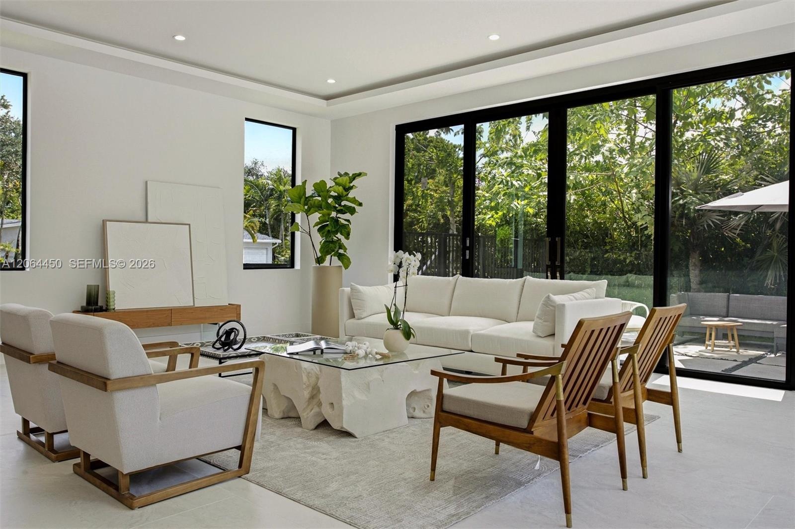 Great room facing the kitchen and bar seating under soaring ceilings