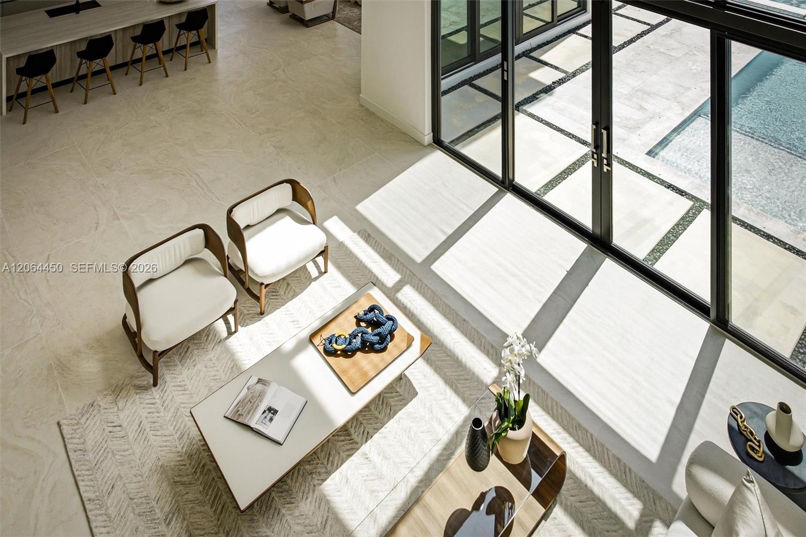 Seamless flow between living, dining, and entry beneath dramatic ceiling heights