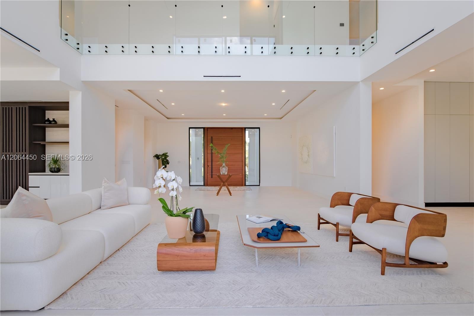 Light filled living area with soaring ceilings and walls of glass to the backyard
