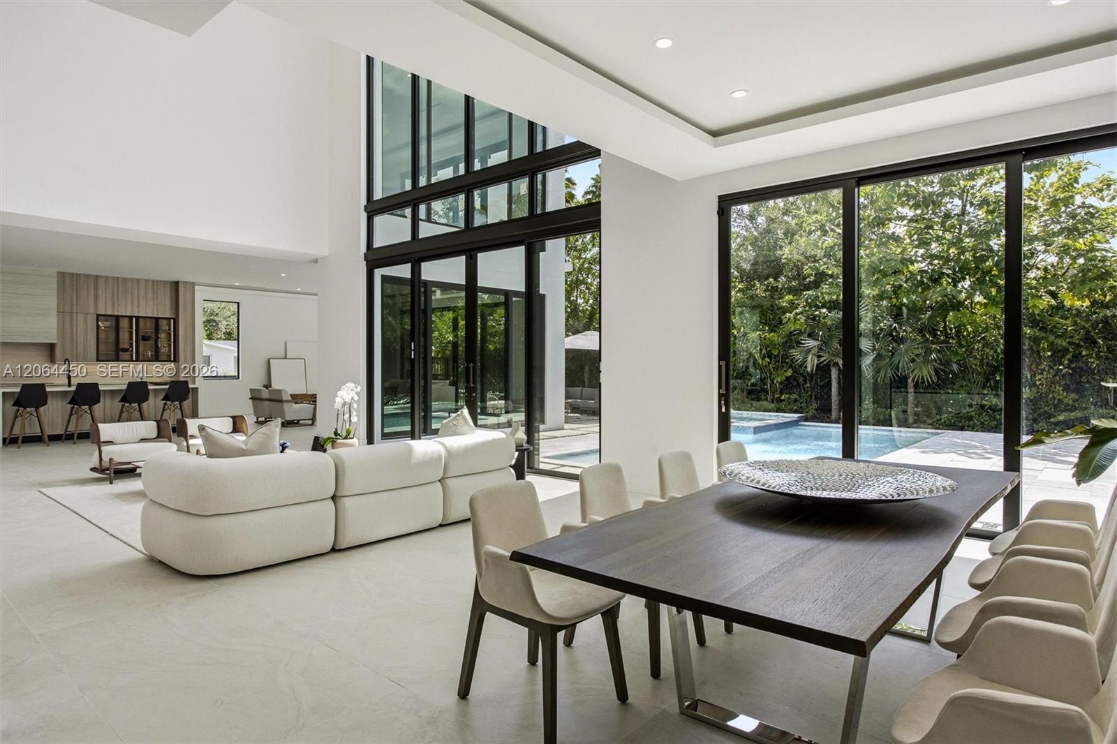 Living area opening to the kitchen with custom wood cabinetry and glass walls