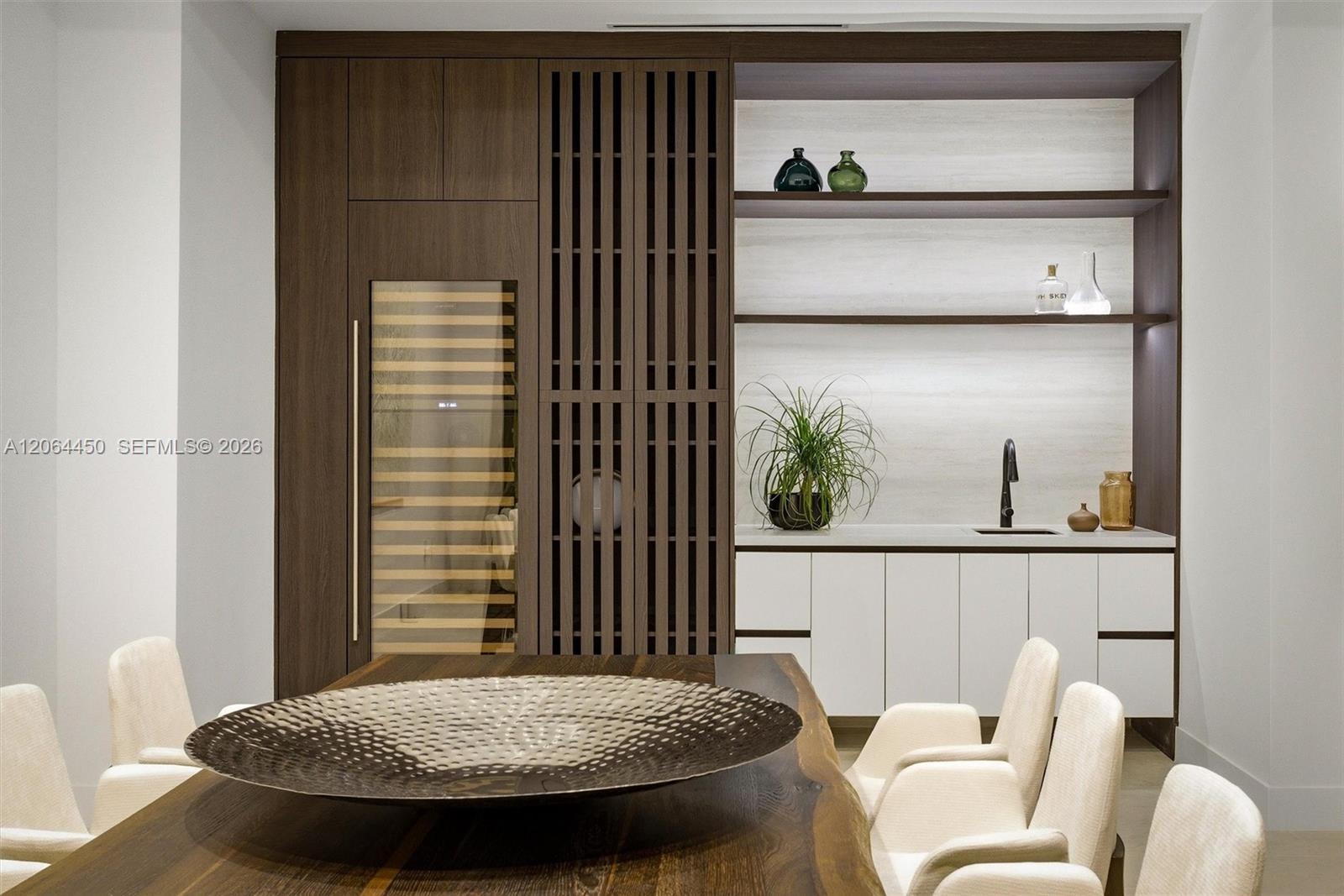 Double-height interior featuring floor-to-ceiling black metal-framed windows, neutral large-format flooring, glass panel staircase railing, and exteri