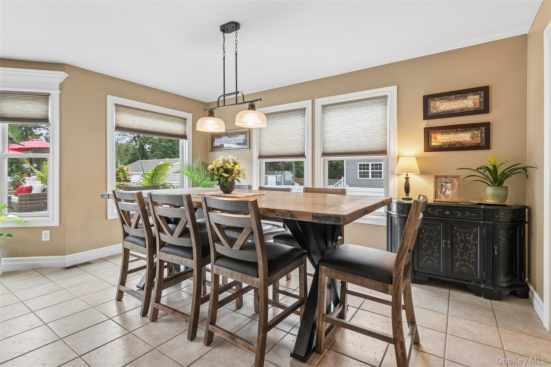 Dining Area Surrounded By Oversized Windows and Sliding Glass Doors