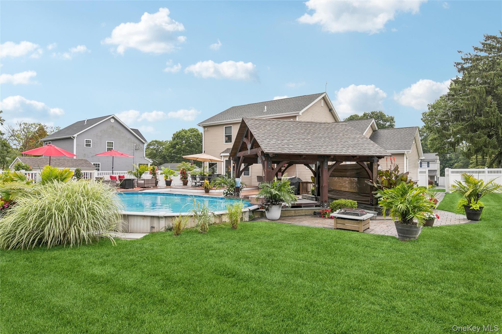 Semi In-Groud Pool Highlights the Vibrant Landscaping and Deck Surrounding