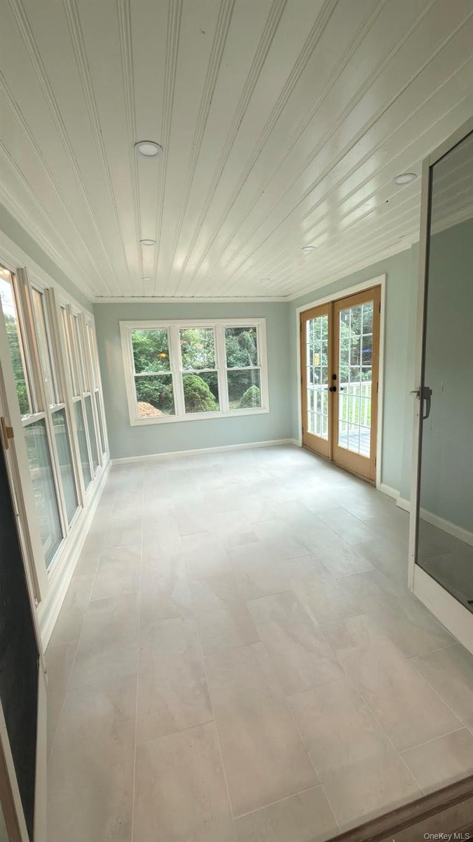 All season porch with radiant heated floors, open to dining room via double doors.
