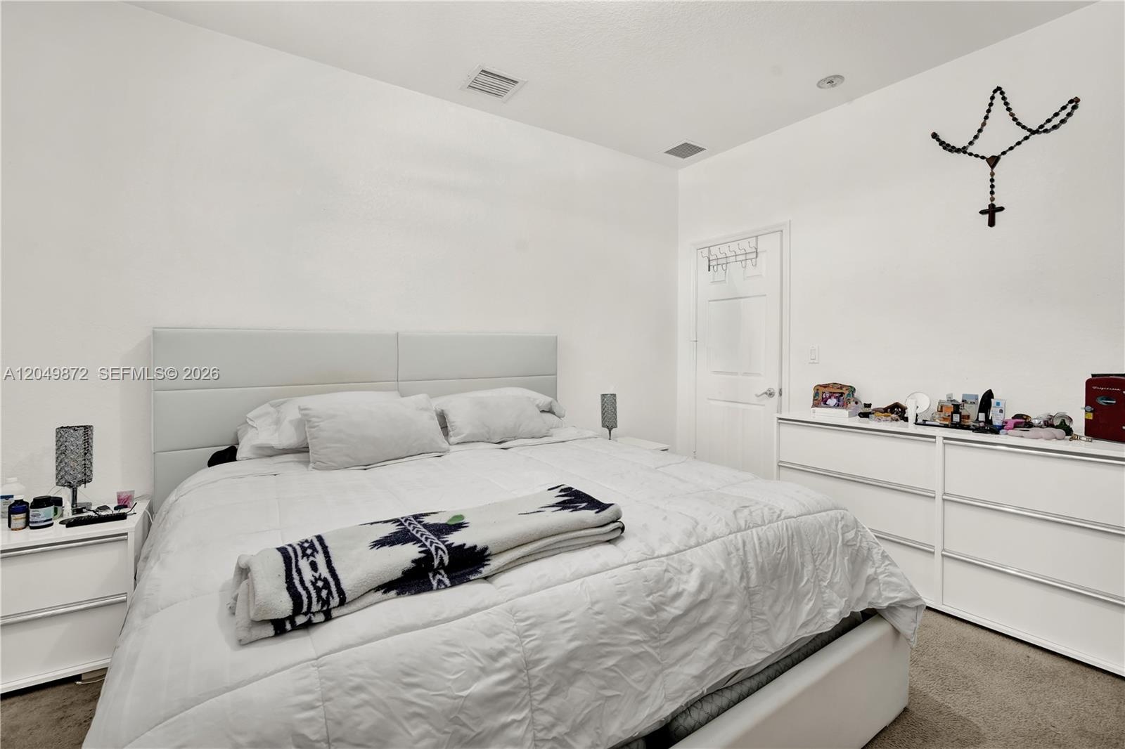 Tray ceiling, wood-finish flooring, two sets of bifold closet doors, and a ceiling fan with integrated lighting