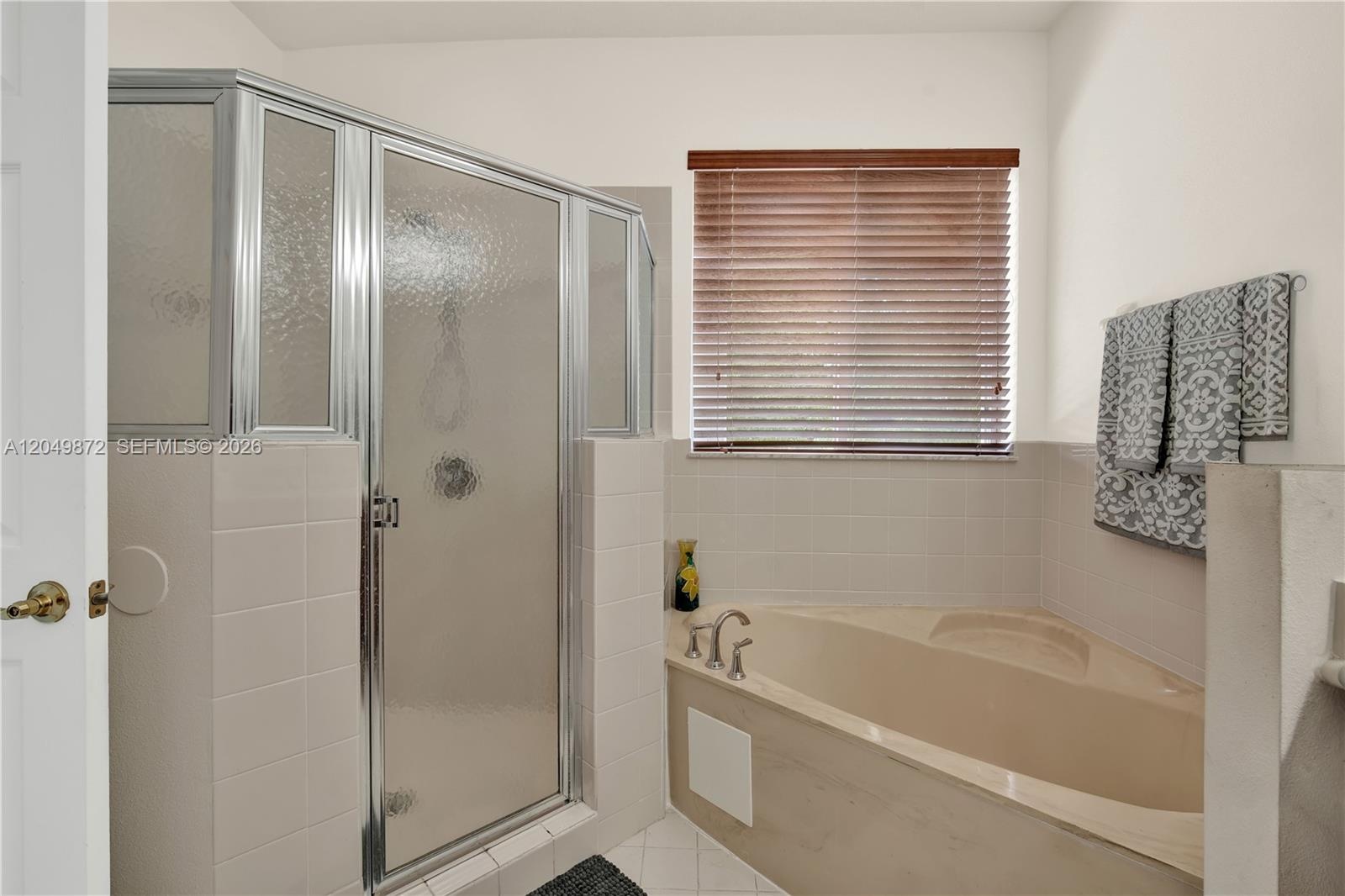 Neutral interior space featuring wood-finish flooring, a ceiling fan, a dual-panel closet, and a multi-pane door