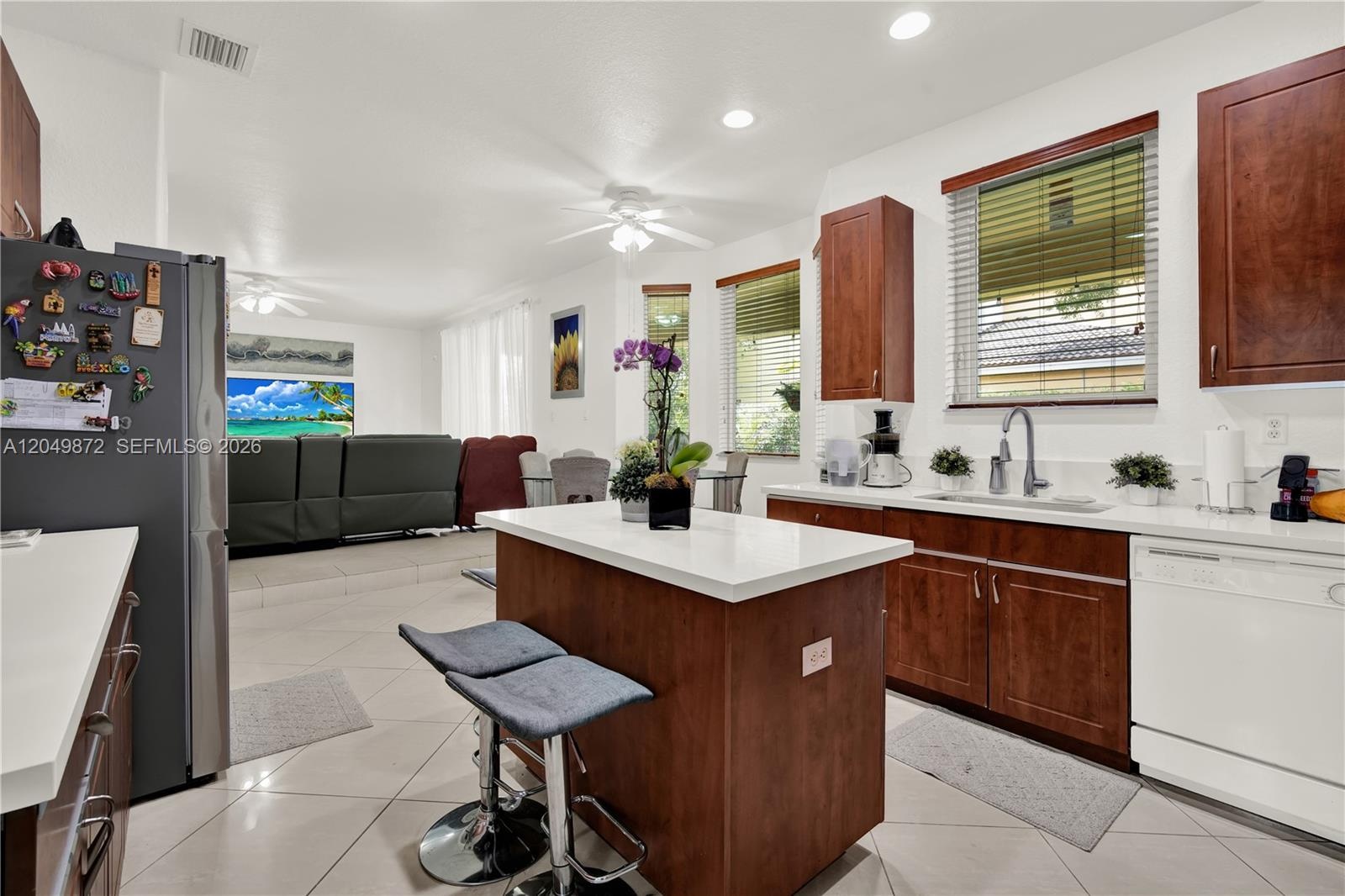 Neutral-toned tile flooring, white wall finish, single-hung window with a blind, and a central ceiling fan