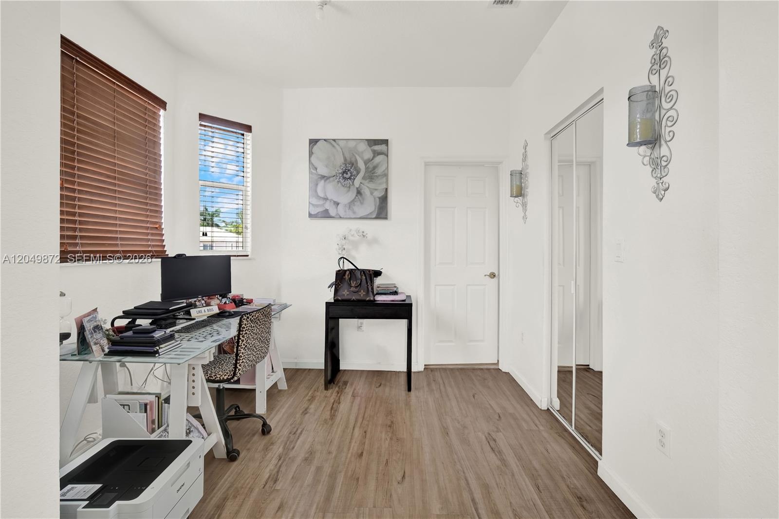 Wood-finish flooring, ceiling fan, dual windows with multi-pane and sliding configurations, and double-door reach-in closet