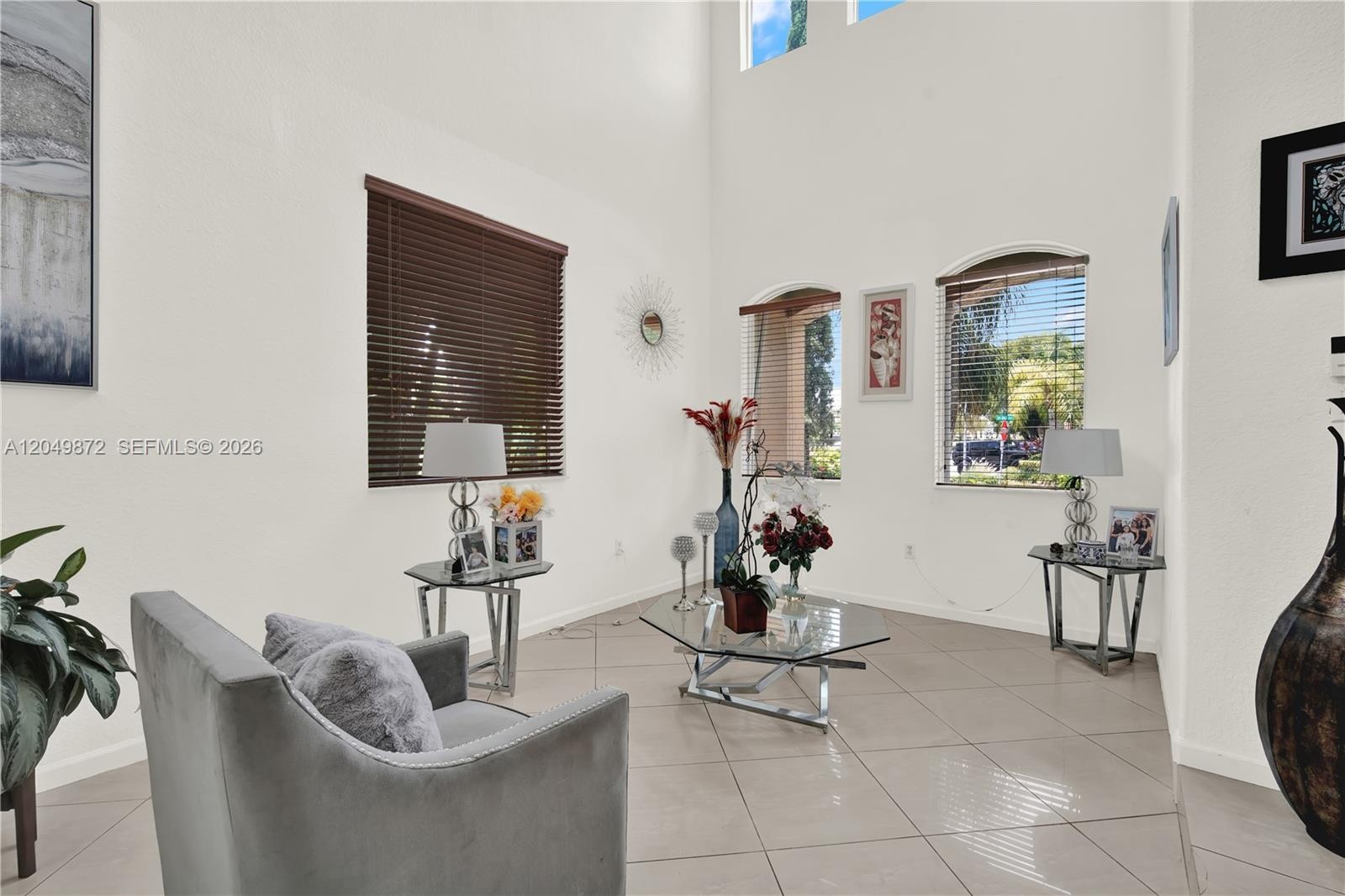 Kitchen featuring natural wood-finish cabinetry, solid-surface countertops, and a stainless steel French-door refrigerator, complemented by tile floor