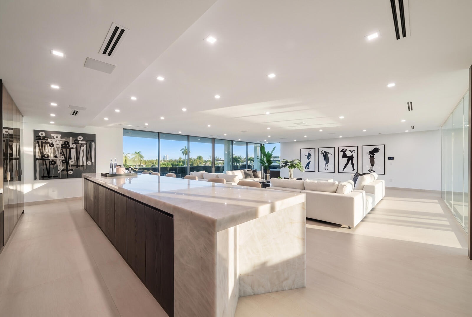 Spectacular third-floor sky lounge anchored by a dramatic illuminated onyx bar, expansive entertaining areas, and walls of glass opening to the terrac