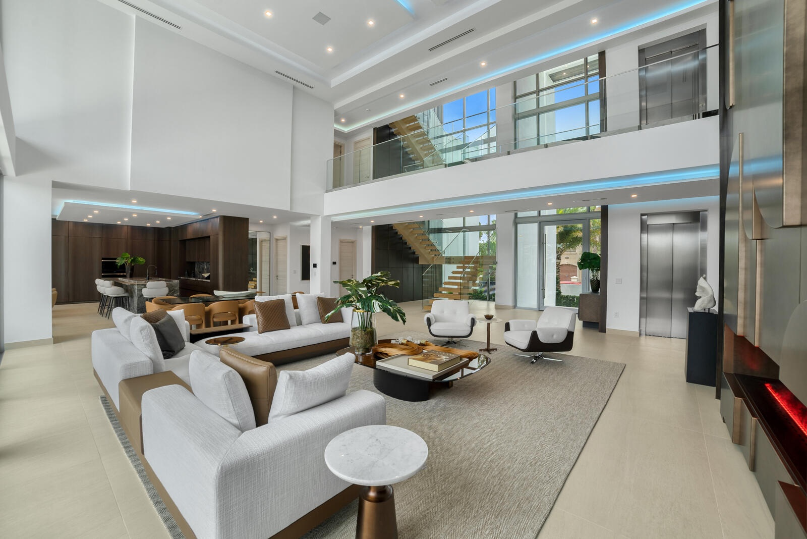Grand interior perspective showcasing the floating wood staircase, frameless glass railings, commercial-grade elevator, and customizable architectural