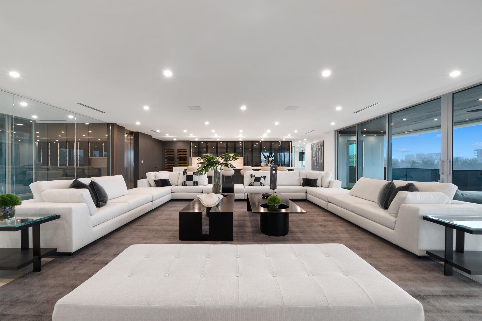 Expansive third-floor entertainment lounge with multiple conversation areas, contemporary designer furnishings, and seamless access to the covered ter