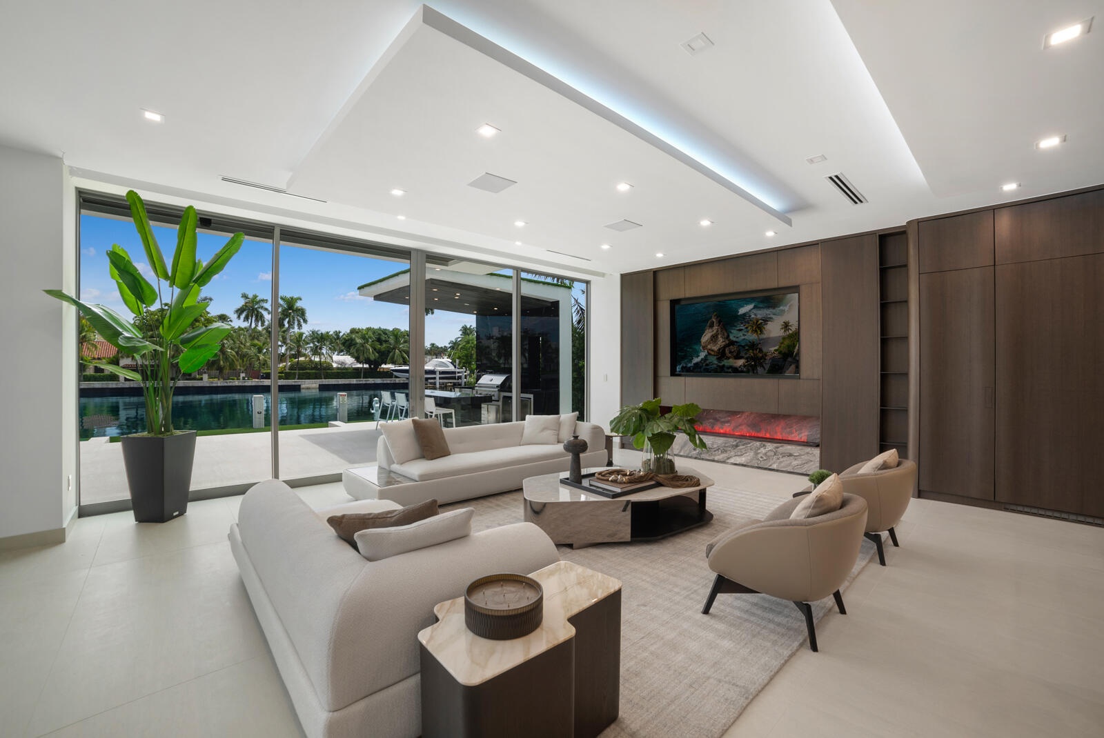 Sophisticated family room positioned beside the showpiece kitchen and separate butler’s kitchen, offering custom cabinetry, a linear fireplace, archit