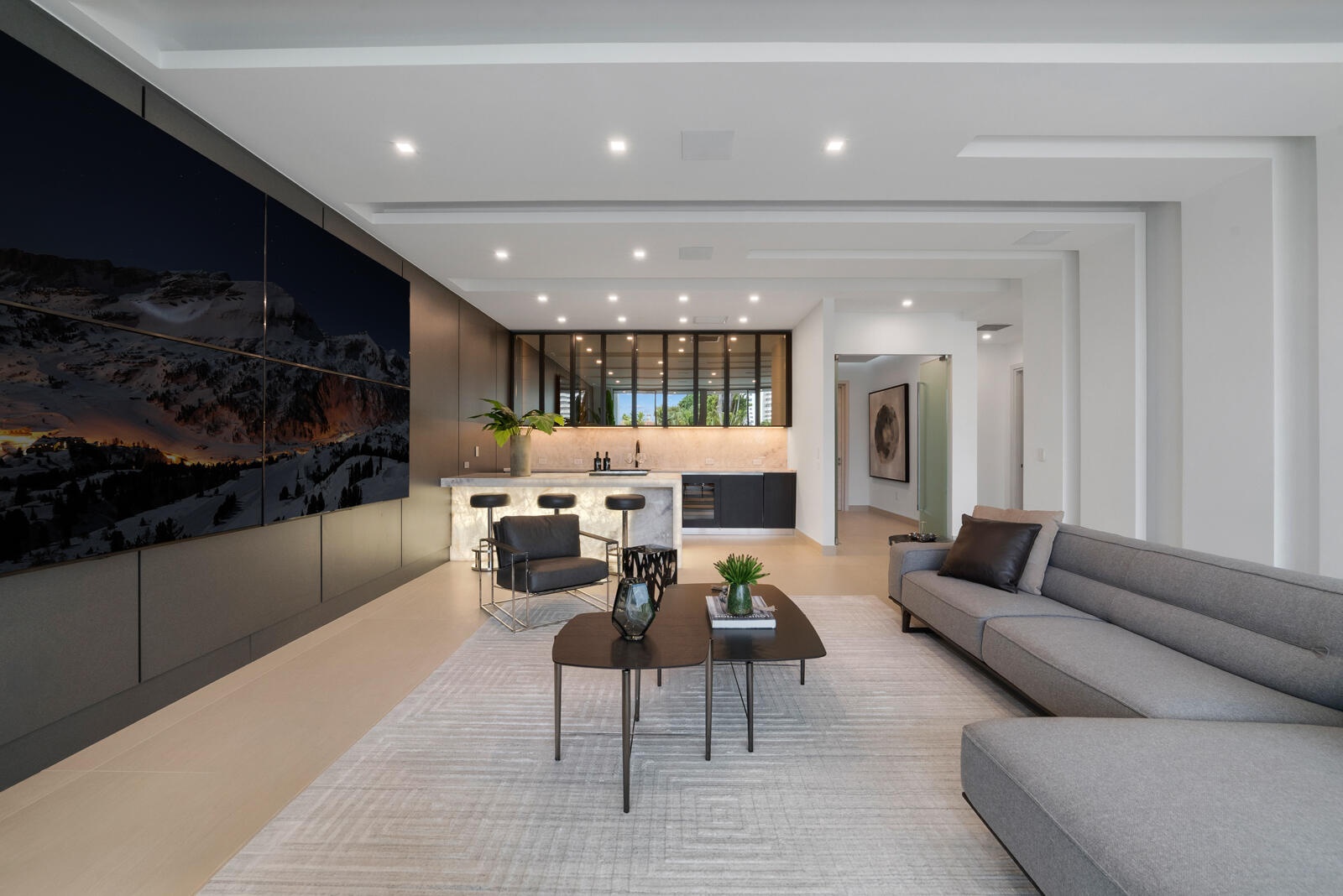 Exceptional first-floor VIP guest suite featuring a spacious private lounge, oversized media wall, full bar, designer finishes, and a private bedroom 