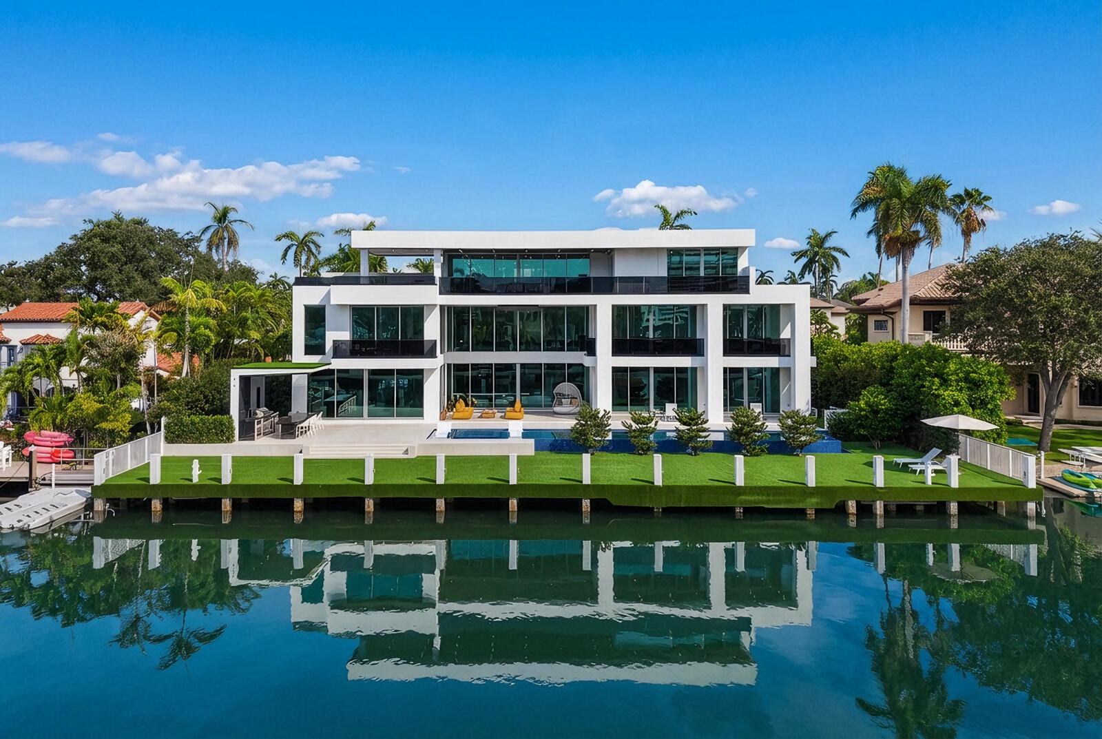 Magnificent waterfront estate commanding 125 feet of deep-water frontage on an exceptionally wide canal, featuring a spectacular 75-foot infinity-edge
